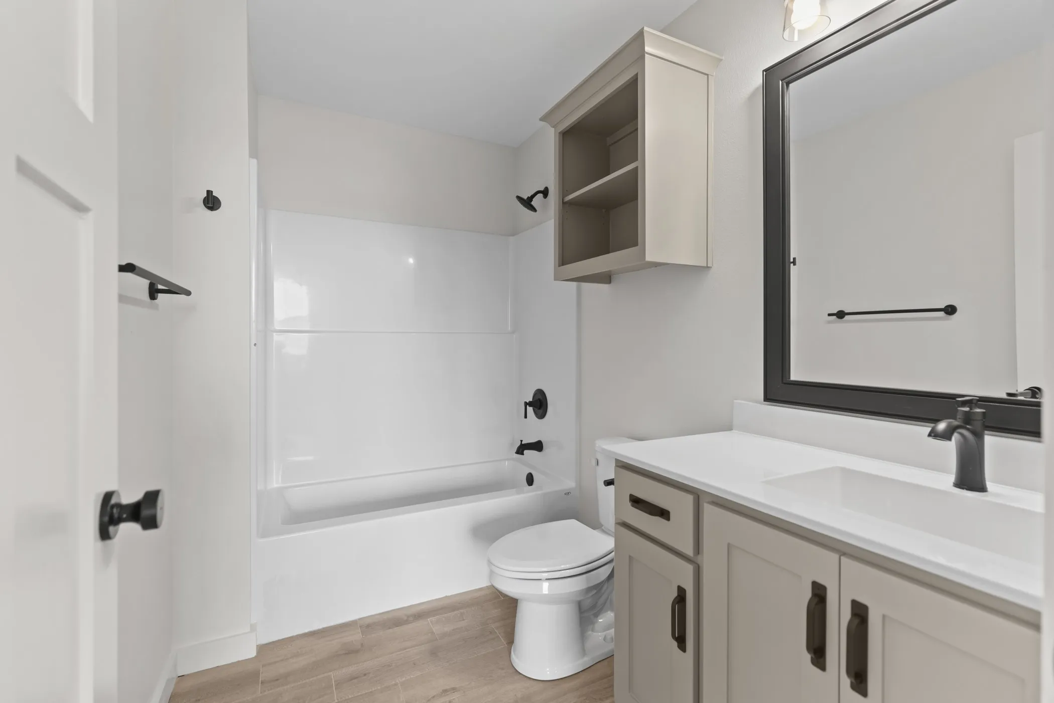 White-paneled bathtub and shower combination with matte black fixtures