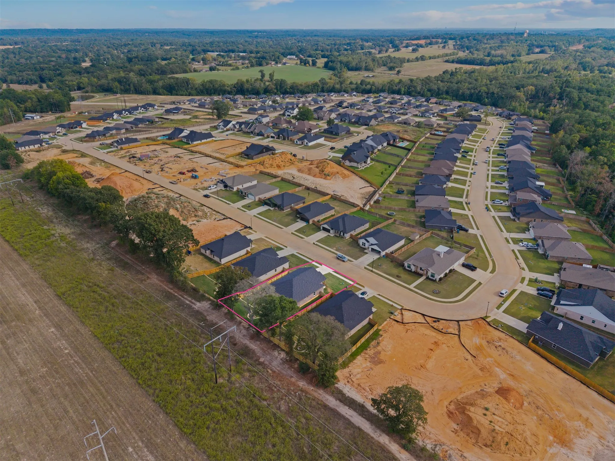Residential development with established and developing homesites, paved streets, and abundant tree coverage in the surrounding landscape