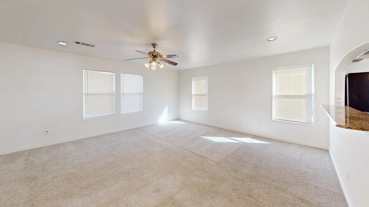Neutral-toned carpeting throughout, multiple windows with blinds, recessed lighting, and a ceiling fan with integrated light fixture