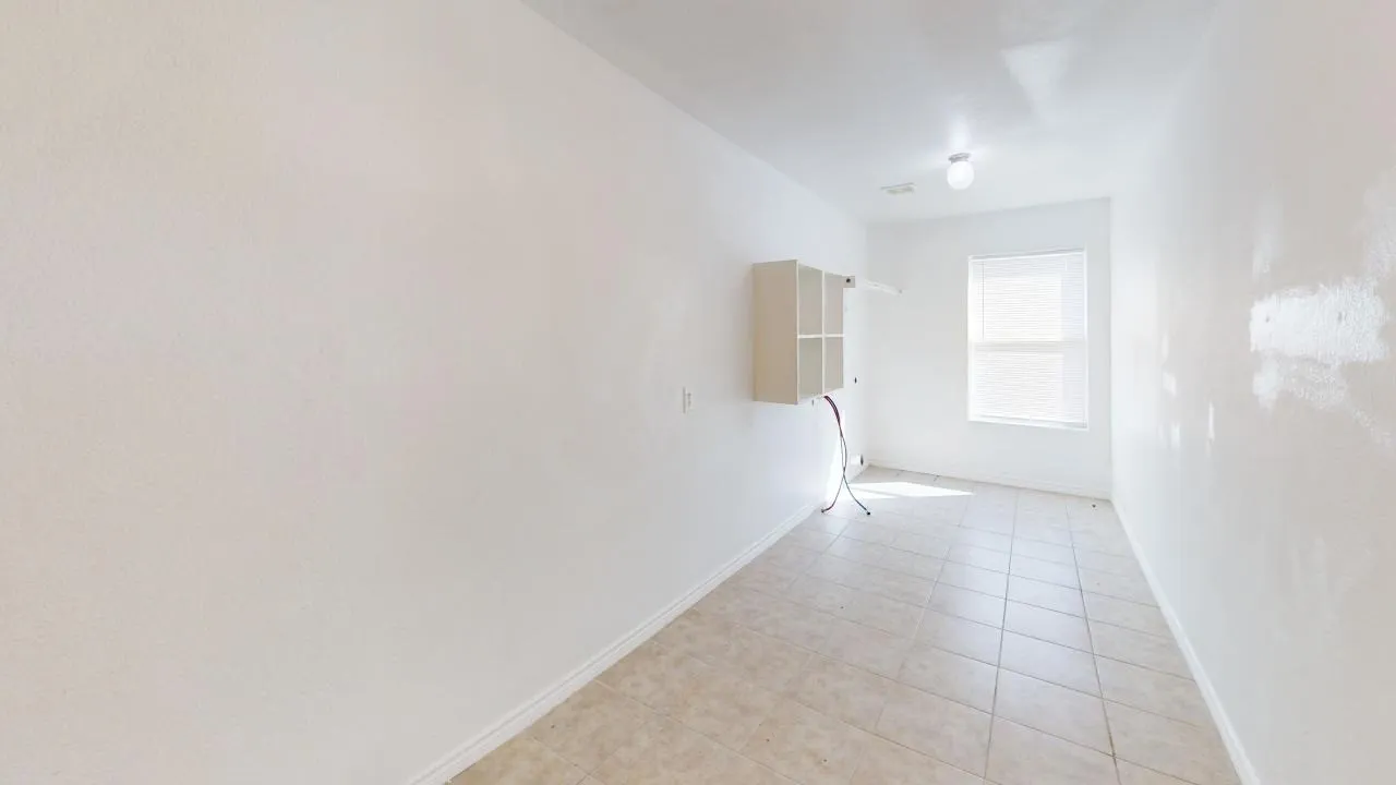 Tiled flooring, white walls, and a window with blinds