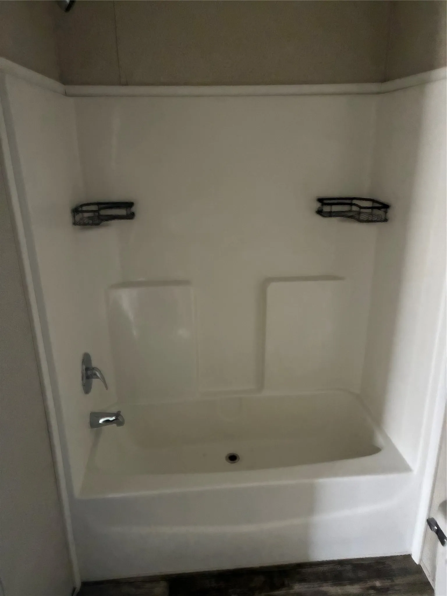 White fiberglass tub and shower combination with chrome fixtures