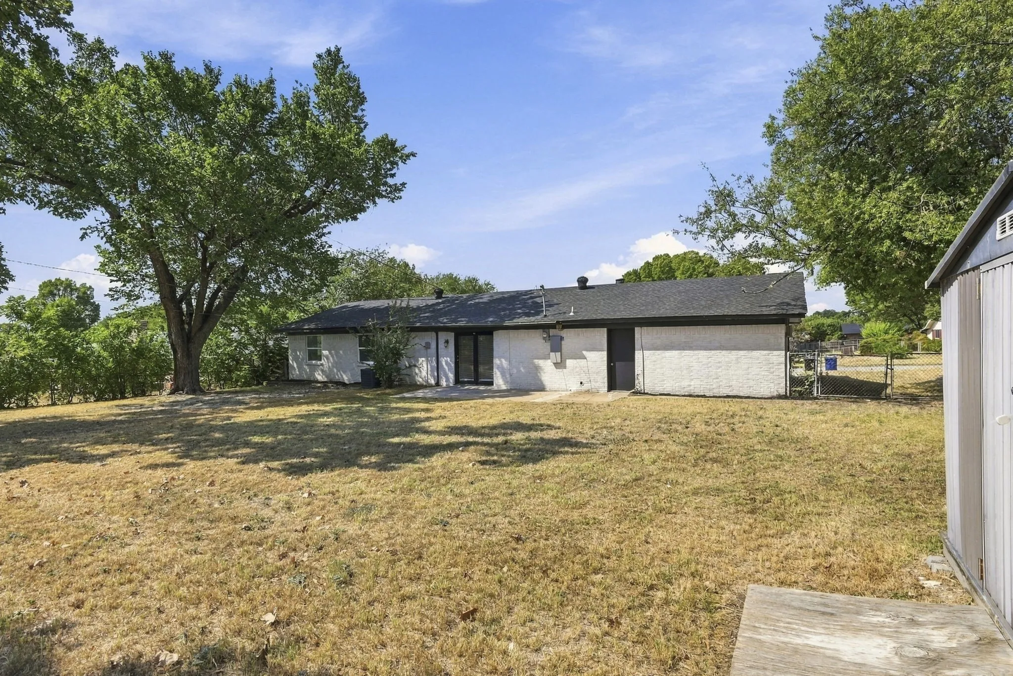 HUGE fenced in backyard with patio, mature trees and shed