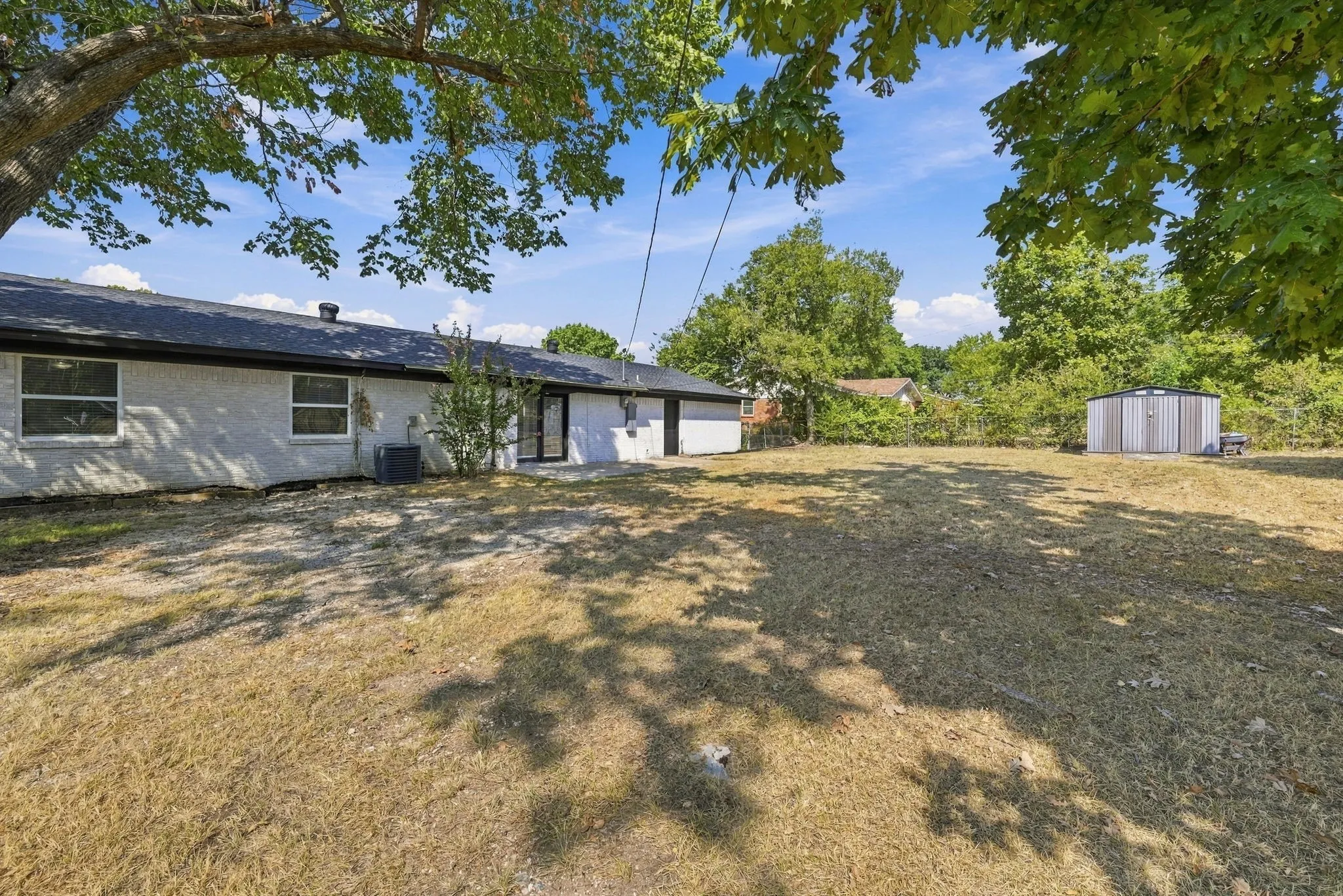 HUGE fenced in backyard with patio, mature trees and shed