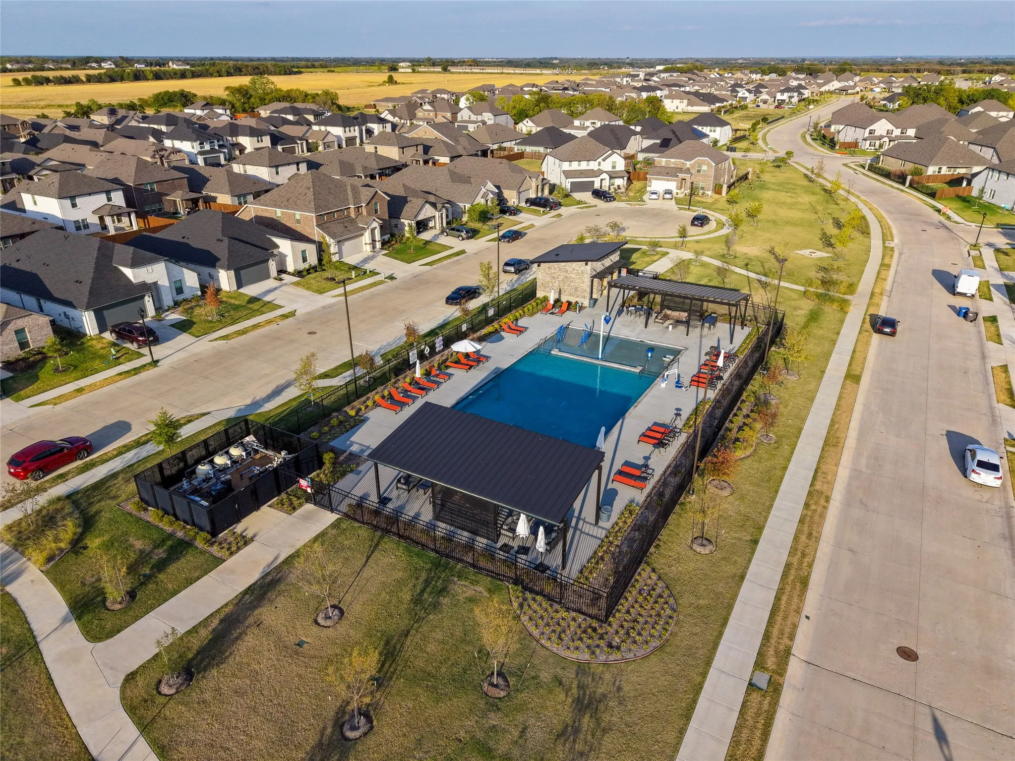 Community swimming pool with an adjacent hot tub and shaded lounging areas