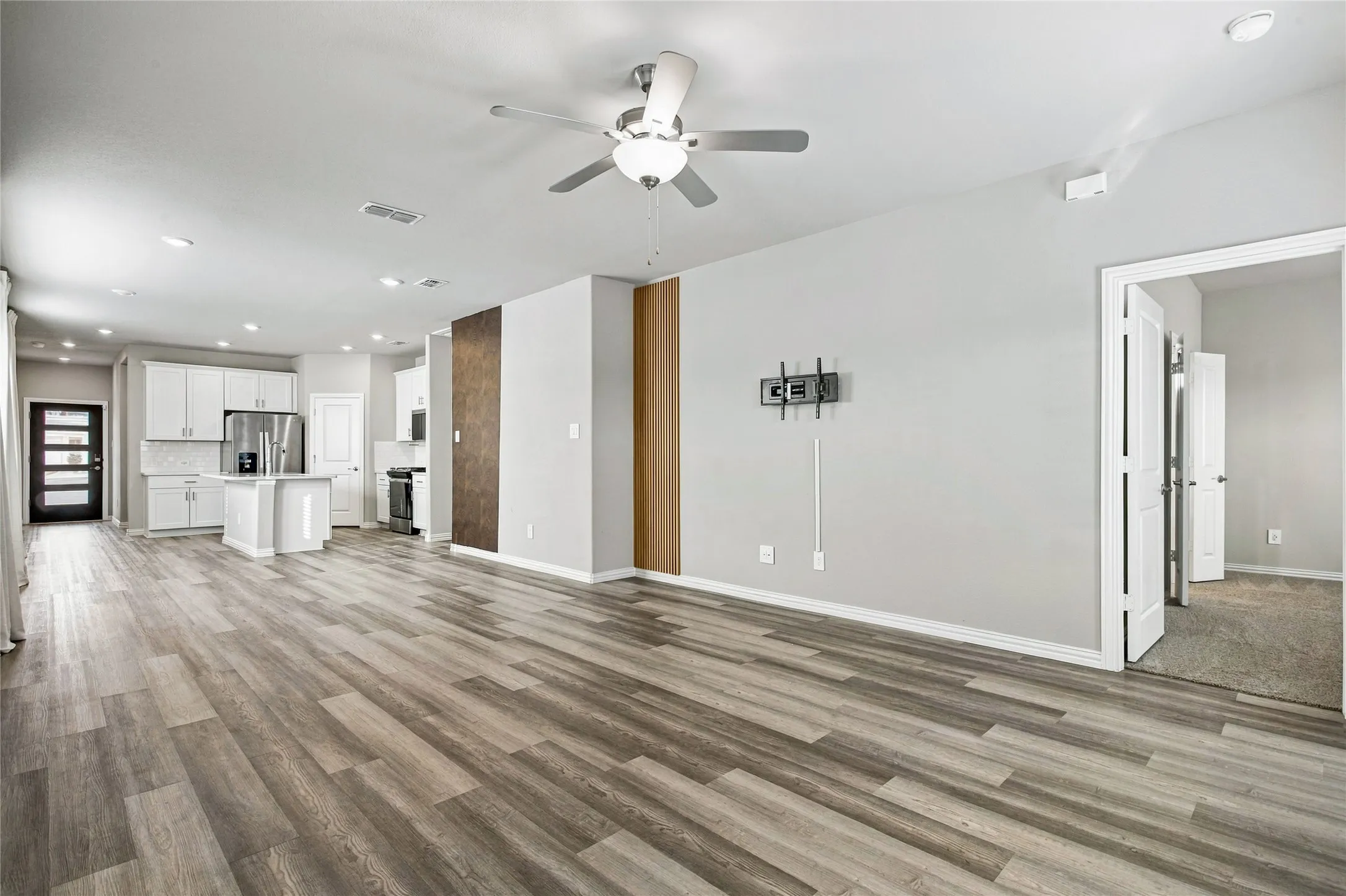 Open-concept room featuring wood-finish flooring, recessed lighting, and a ceiling fan