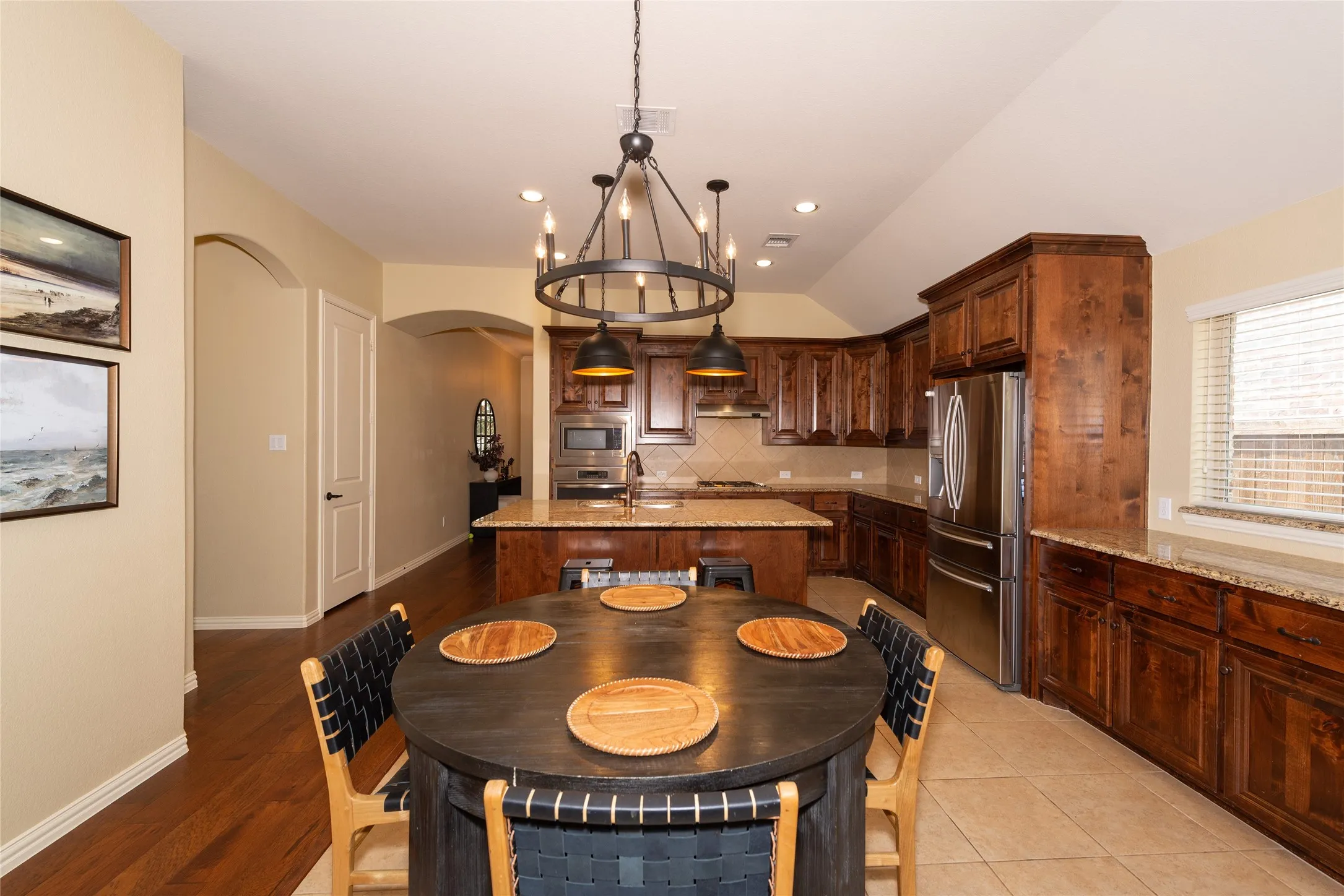 Spacious kitchen featuring rich wood cabinetry, stainless steel appliances, a large center island, and recessed lighting