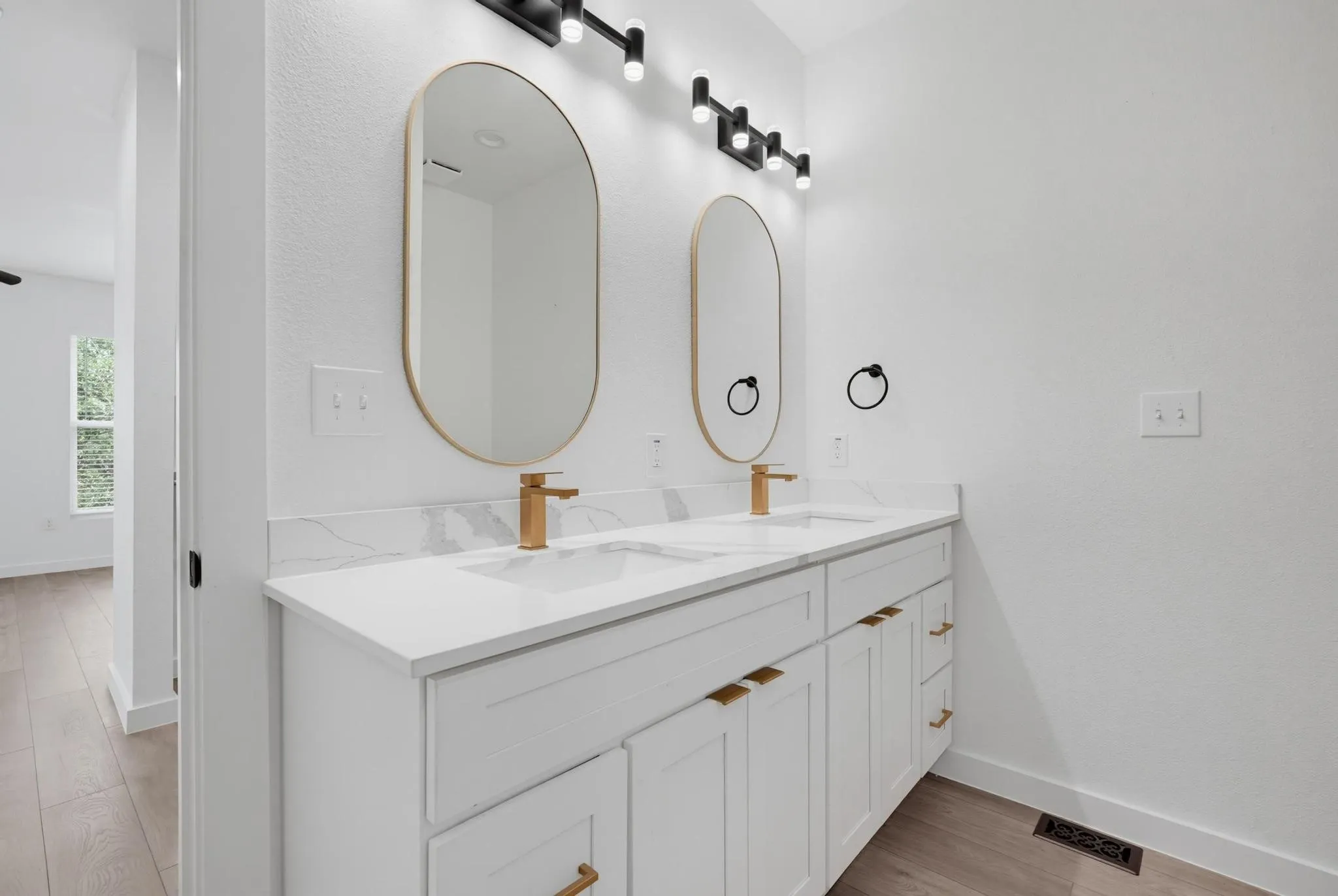 Double vanity with gold-tone hardware, undermount sinks, and white countertops