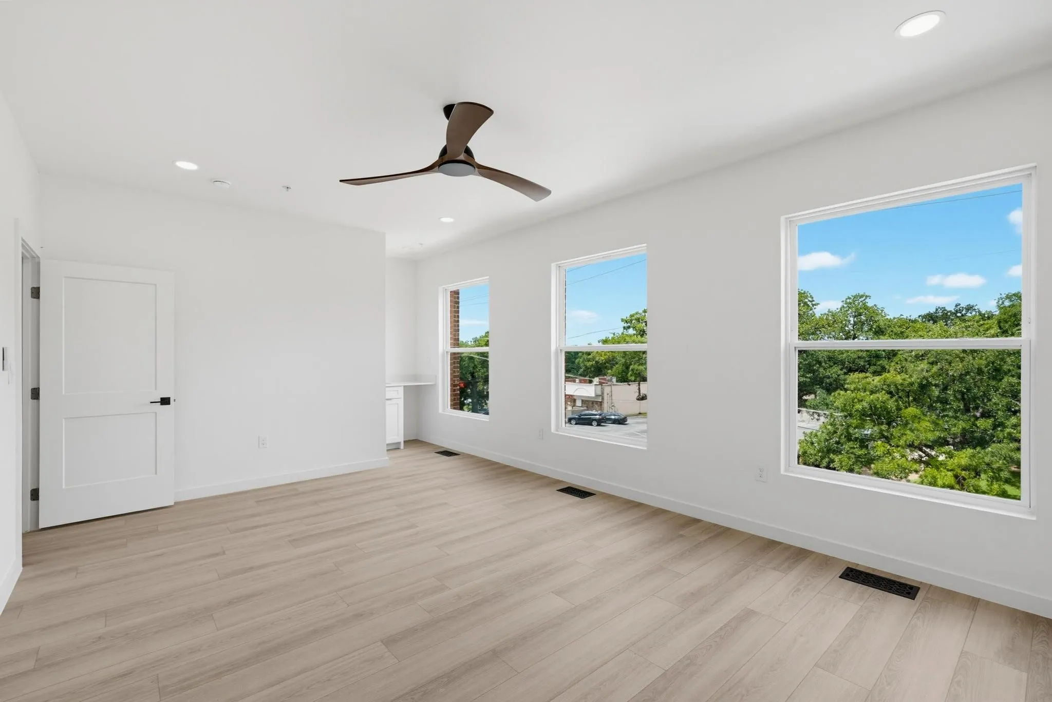 Bright space featuring wood-finish flooring, recessed lighting, and a modern ceiling fan