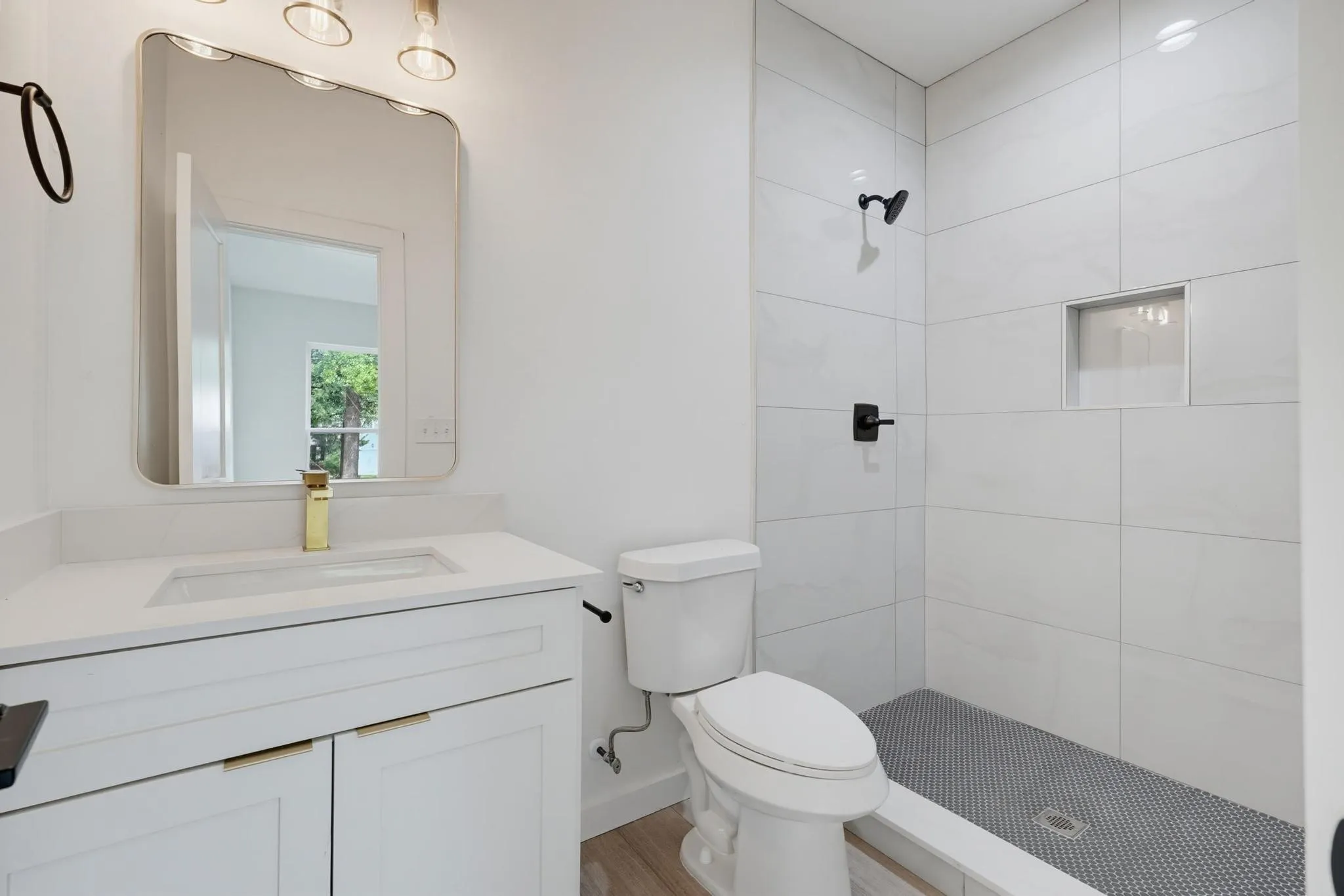 White vanity with a rectangular undermount sink, gold-finish faucet, and coordinating cabinet hardware