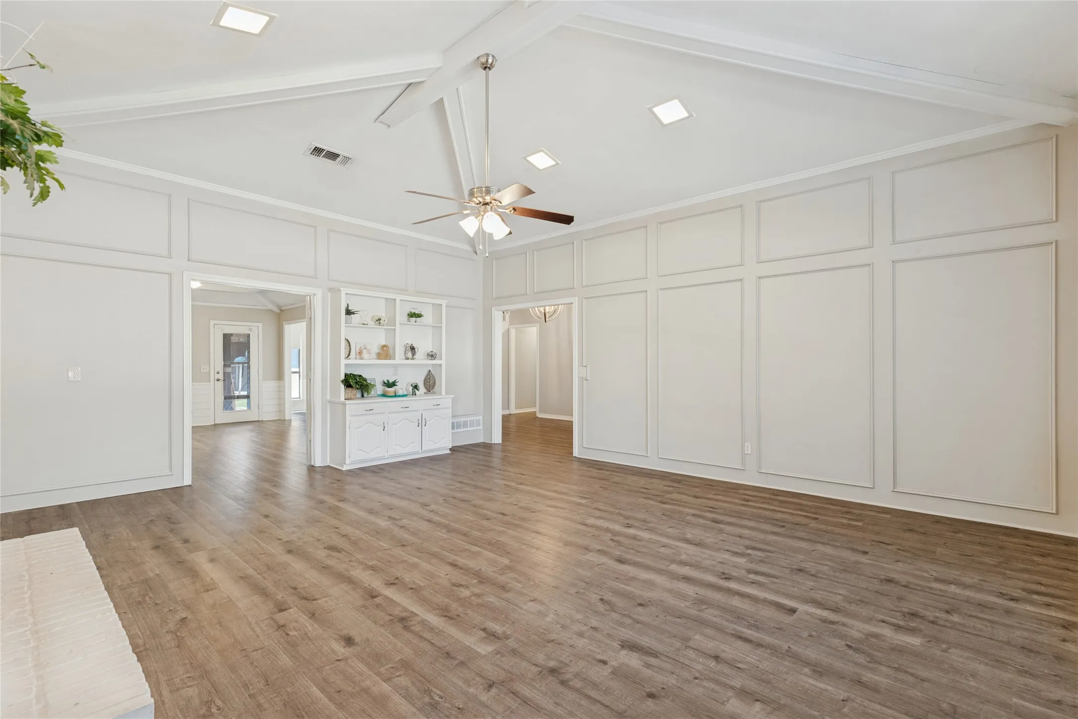 Vaulted ceiling with exposed beams, wood-finish flooring, recessed lighting, ceiling fan, and built-in cabinetry with open shelving, just an amazing room!