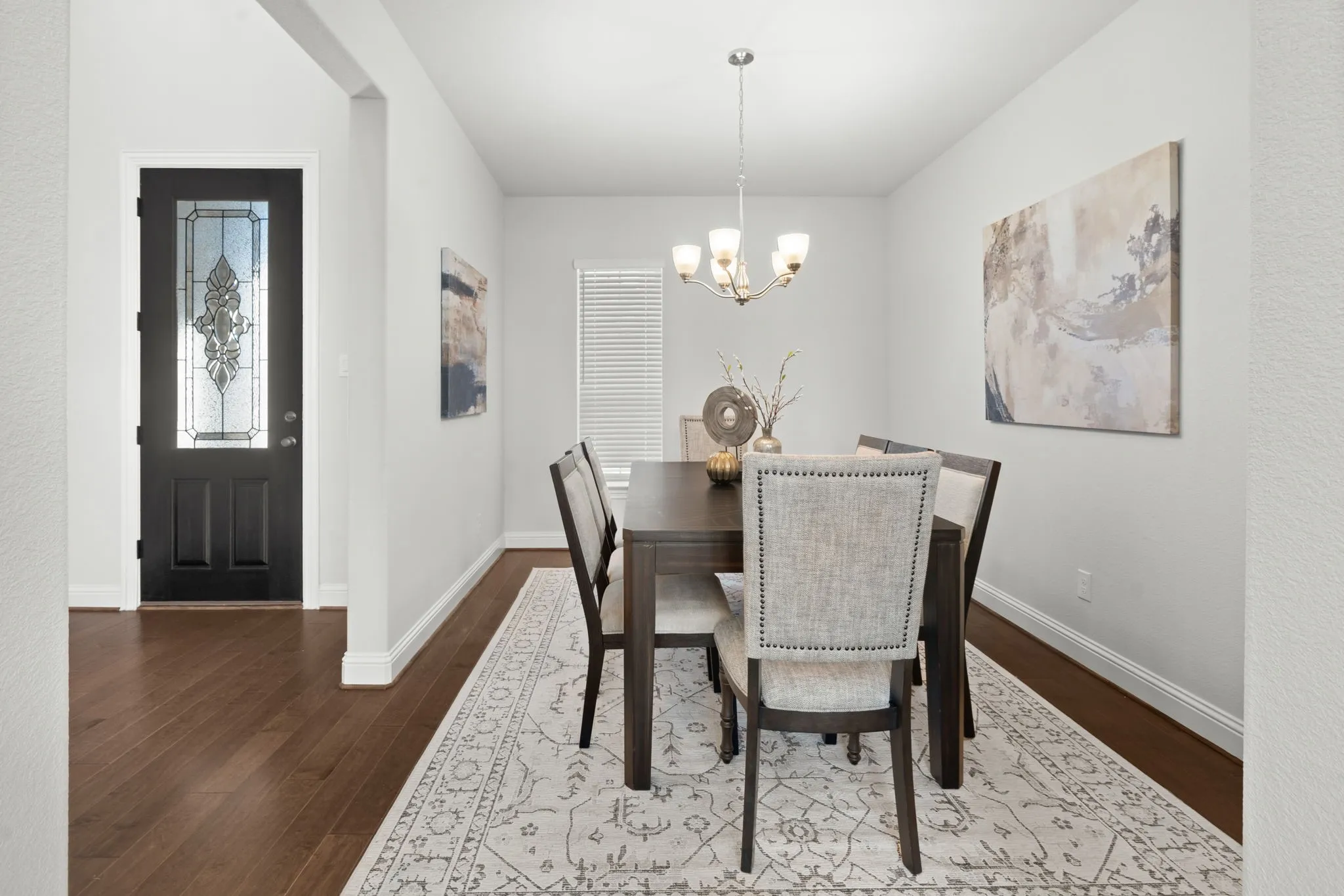 Entryway with a stained glass front door, wood-finish flooring, and a chandelier with glass shades