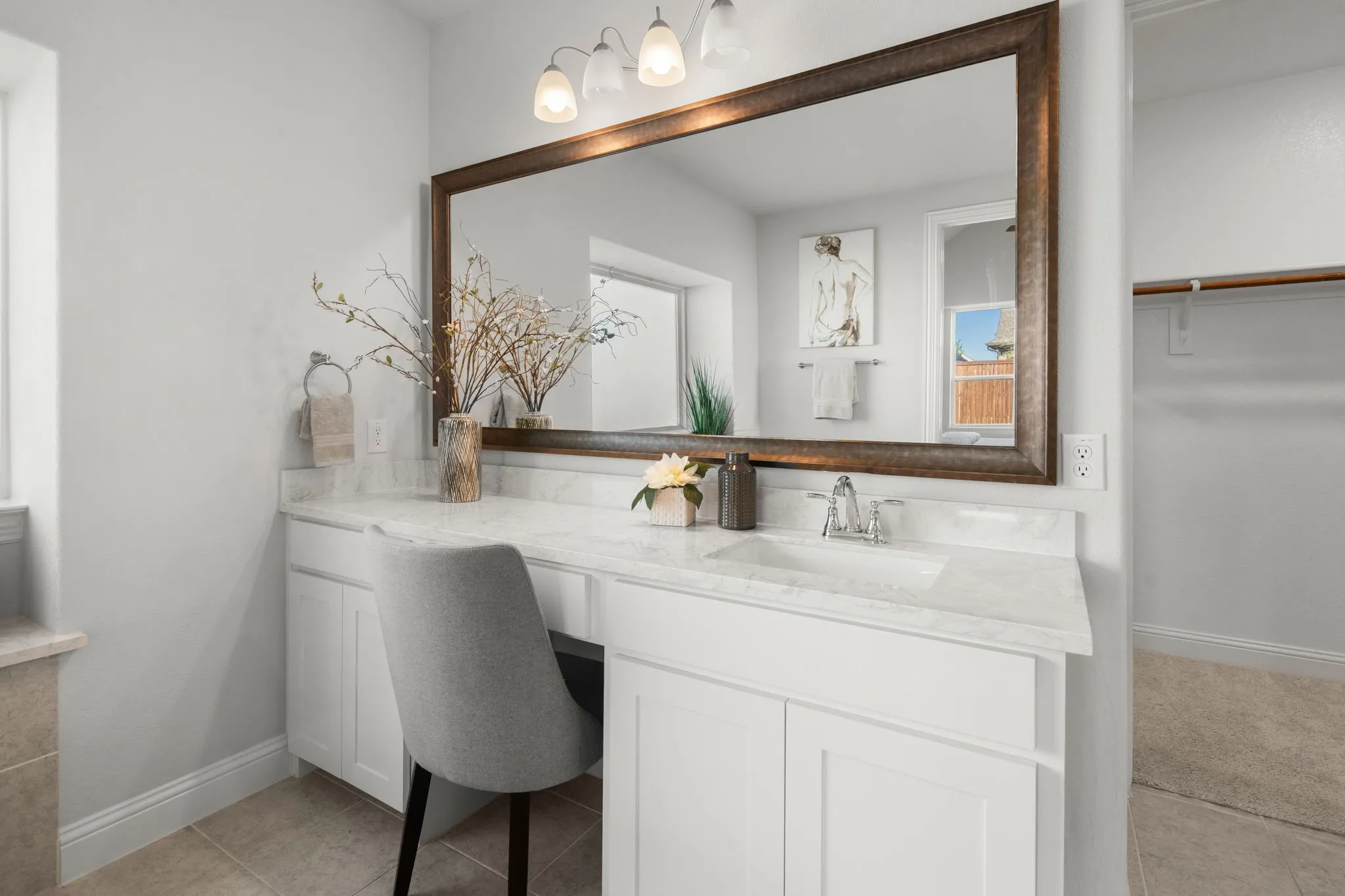 Bathroom vanity featuring a single basin sink, white cabinetry, and a light-toned countertop