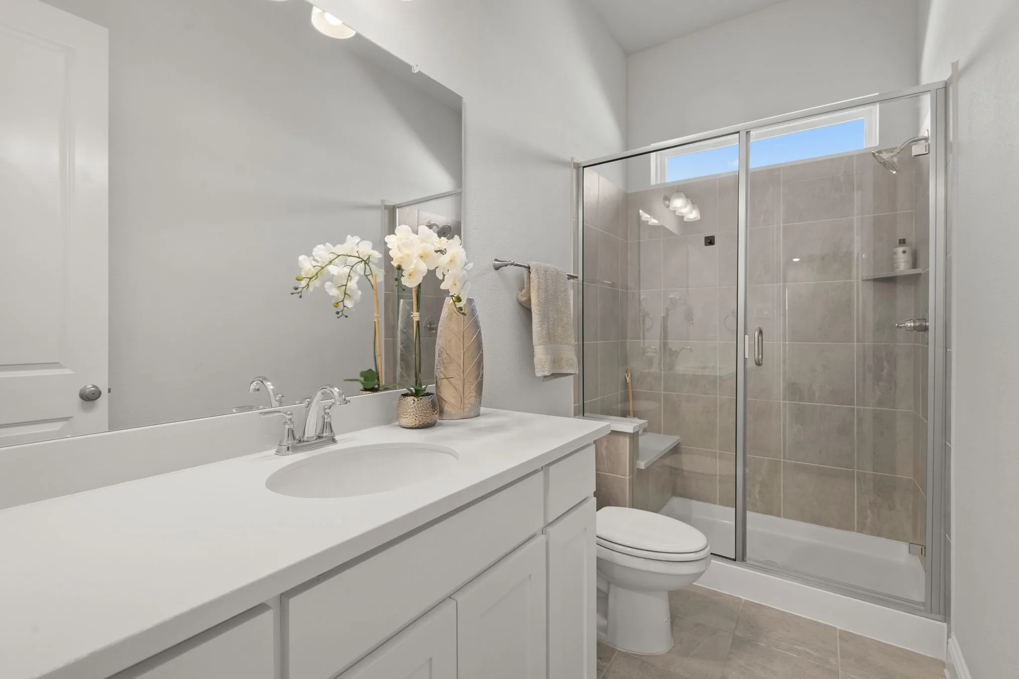 Walk-in shower with glass enclosure, built-in bench, and tiled walls