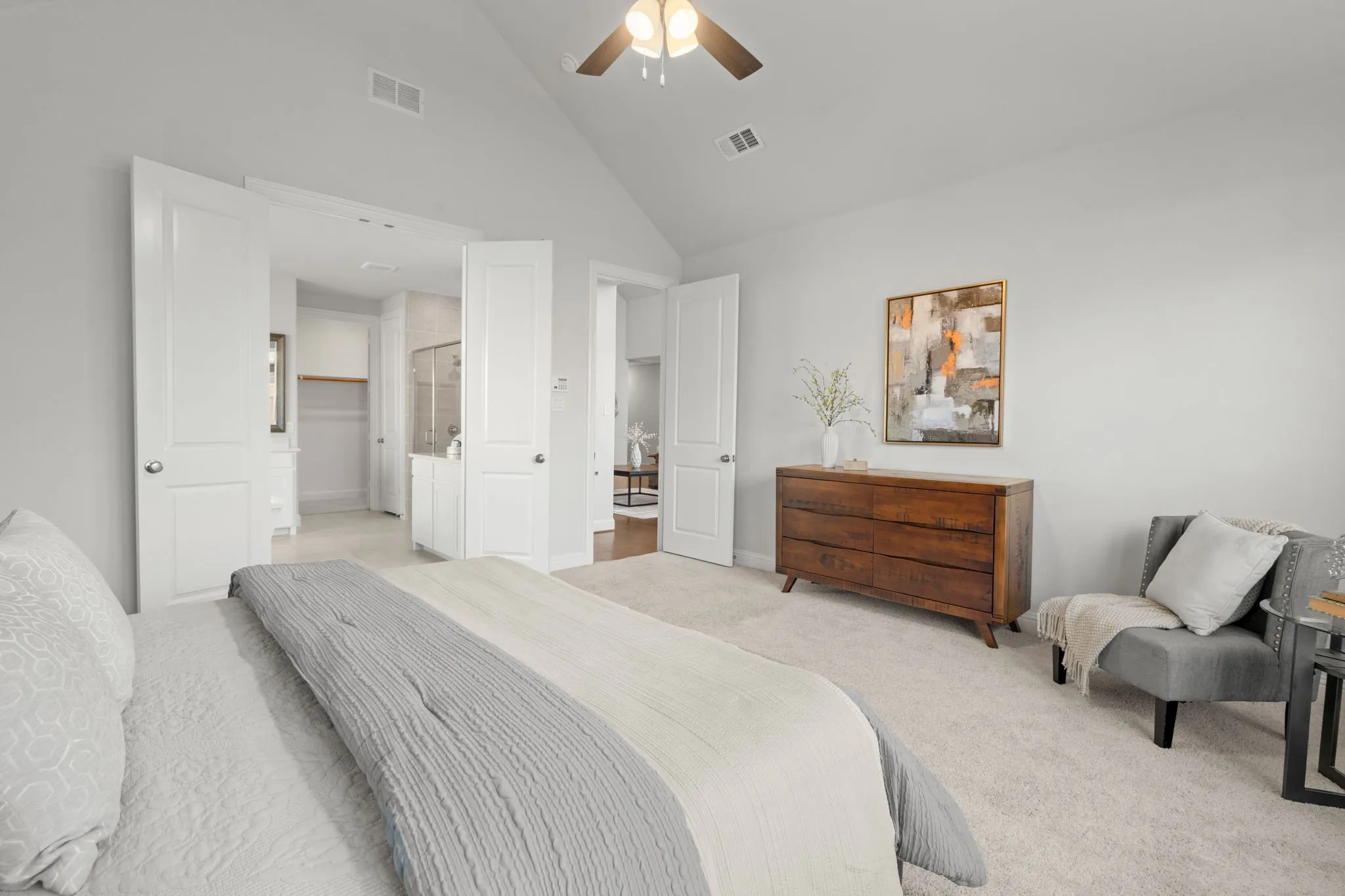 Vaulted ceiling with ceiling fan, light gray wall paint, and white trim