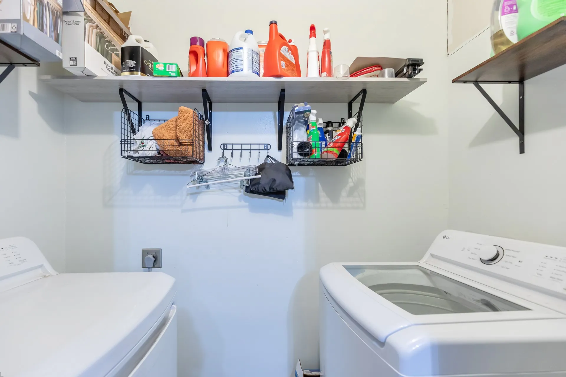 Wall-mounted shelving with black metal brackets and wire baskets