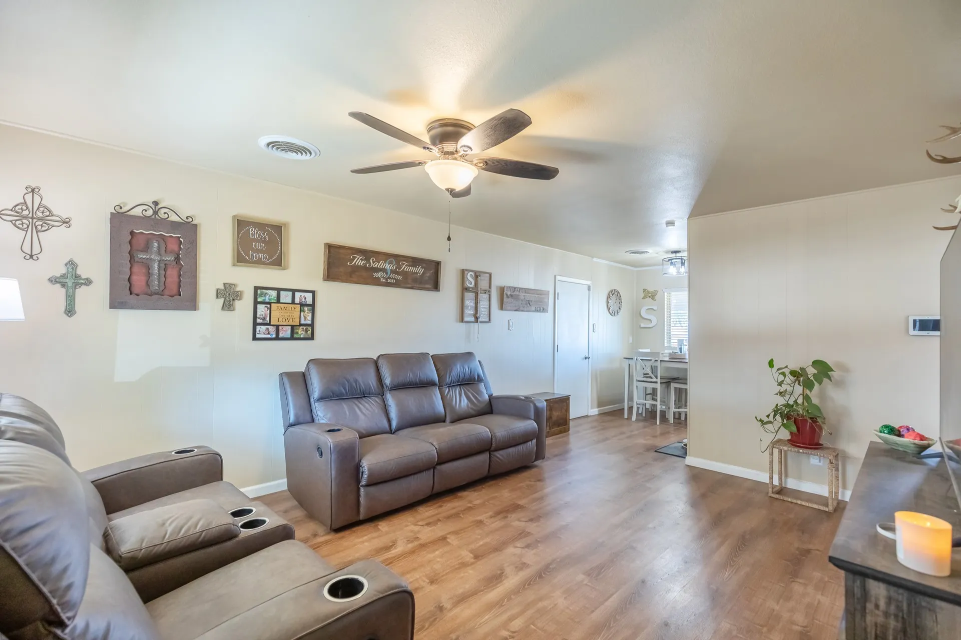 Wood-finish flooring, ceiling fan with integrated lighting, and light-toned wall finishes