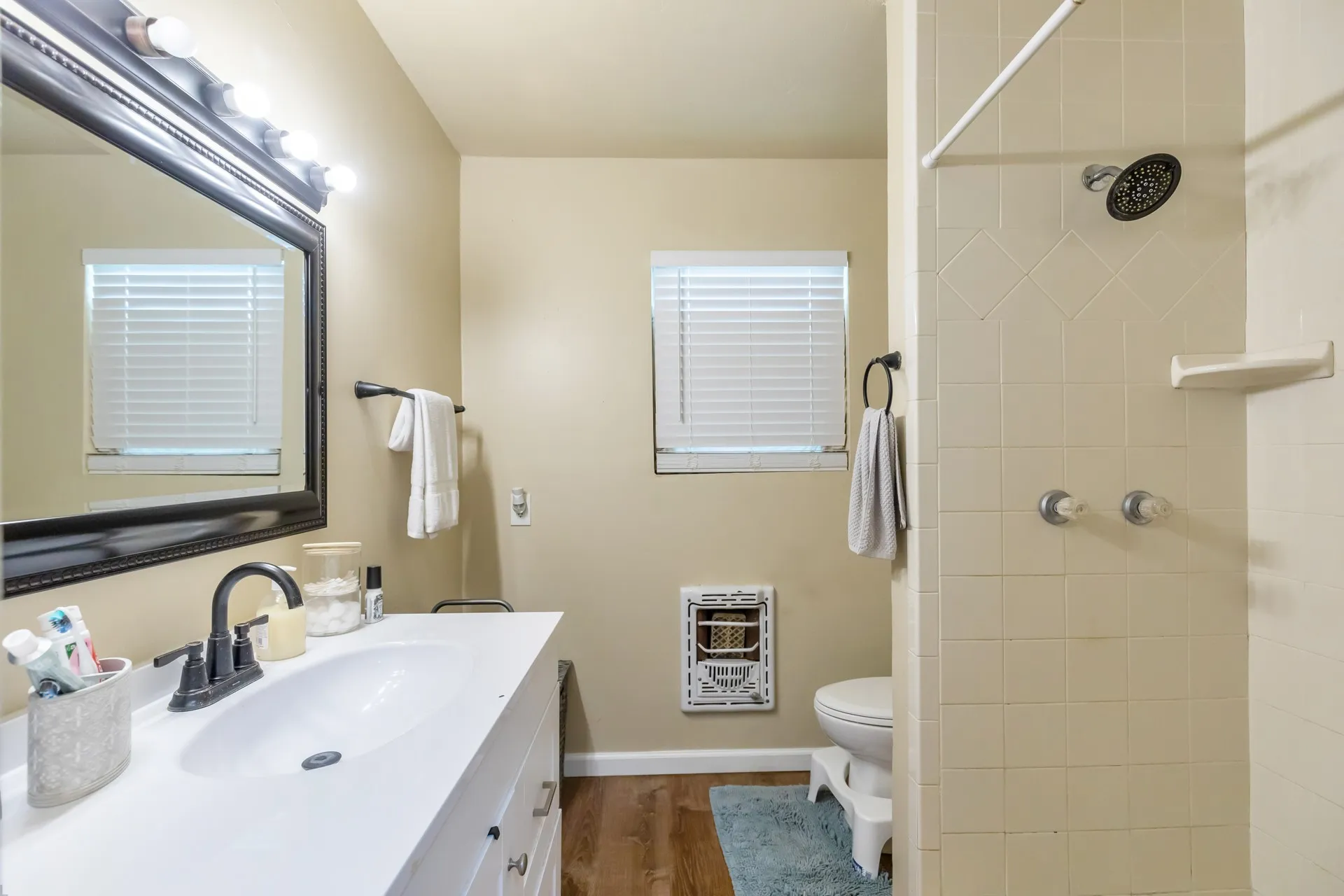 Vanity with a single basin, dark-finish faucet, and coordinating framed mirror