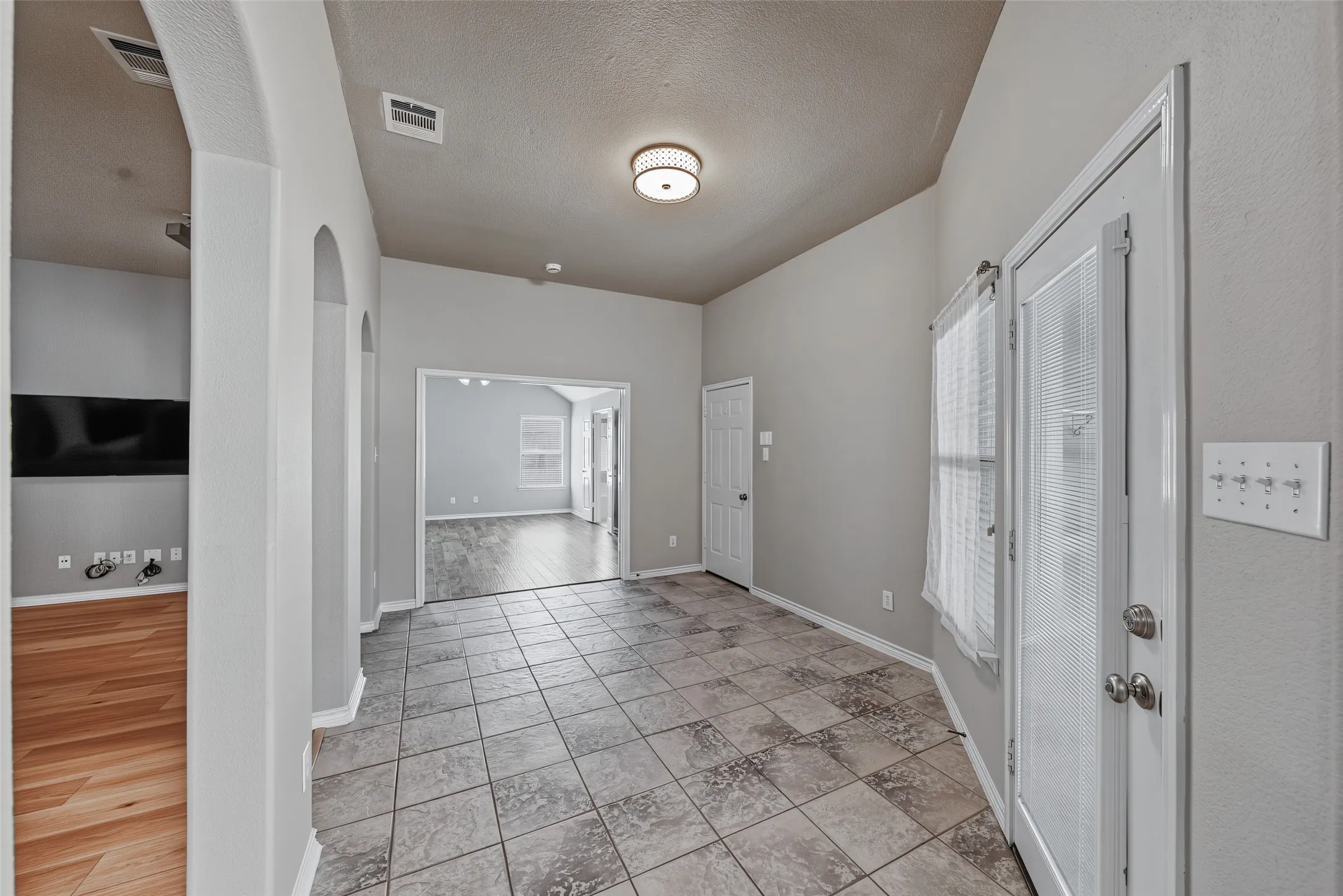 Tiled flooring throughout the main area with arched doorways
