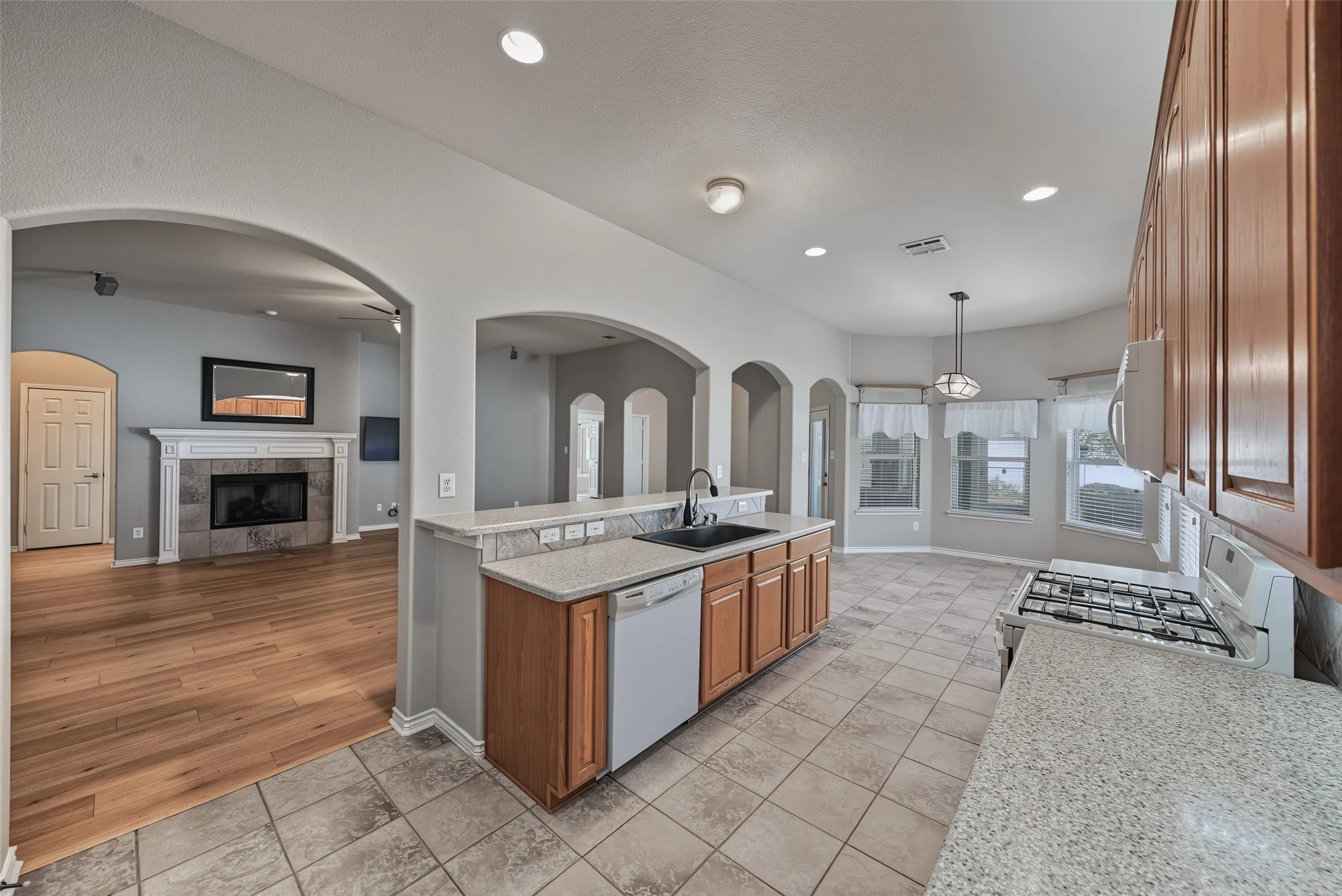 Kitchen featuring a gas range, tile flooring, and light wood-finish cabinetry