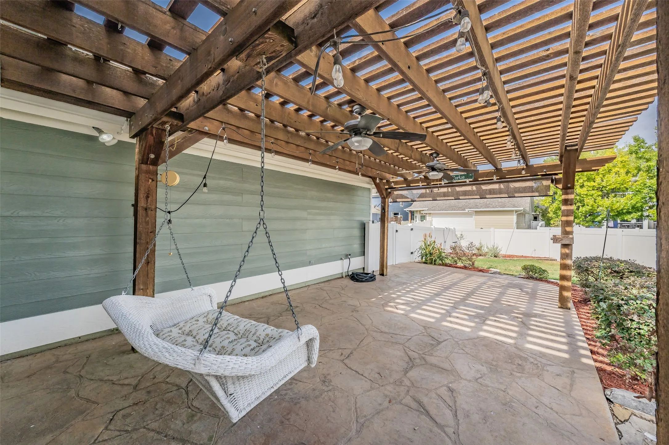 Expansive stamped concrete patio with an overhead wooden pergola