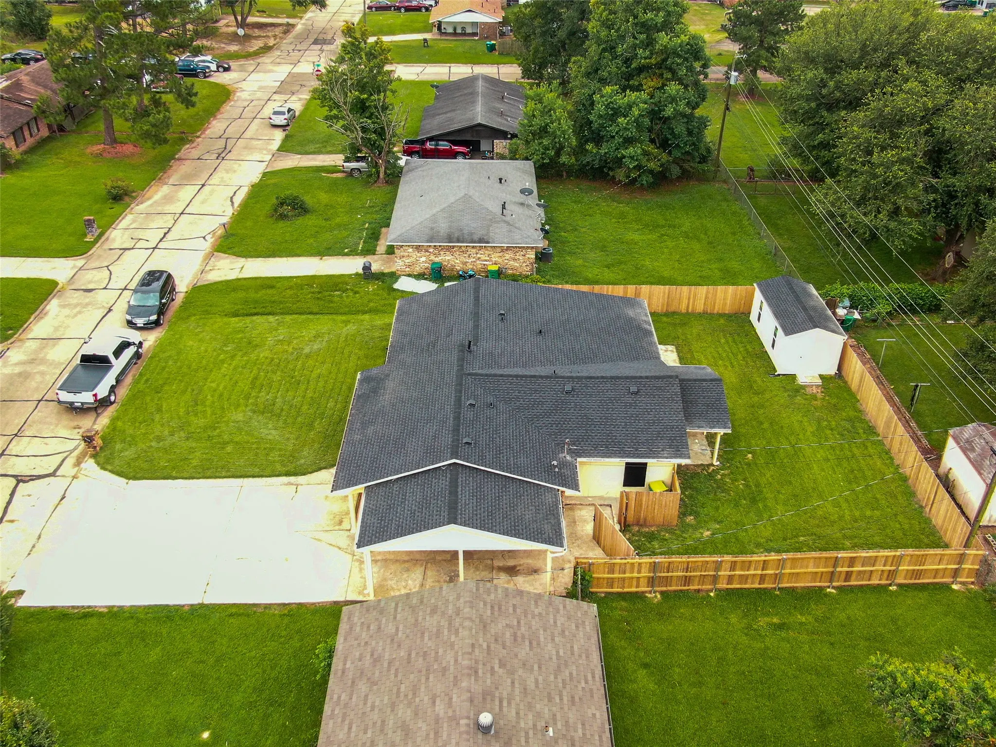 Expansive lot featuring a fenced backyard, detached storage shed, and a concrete driveway