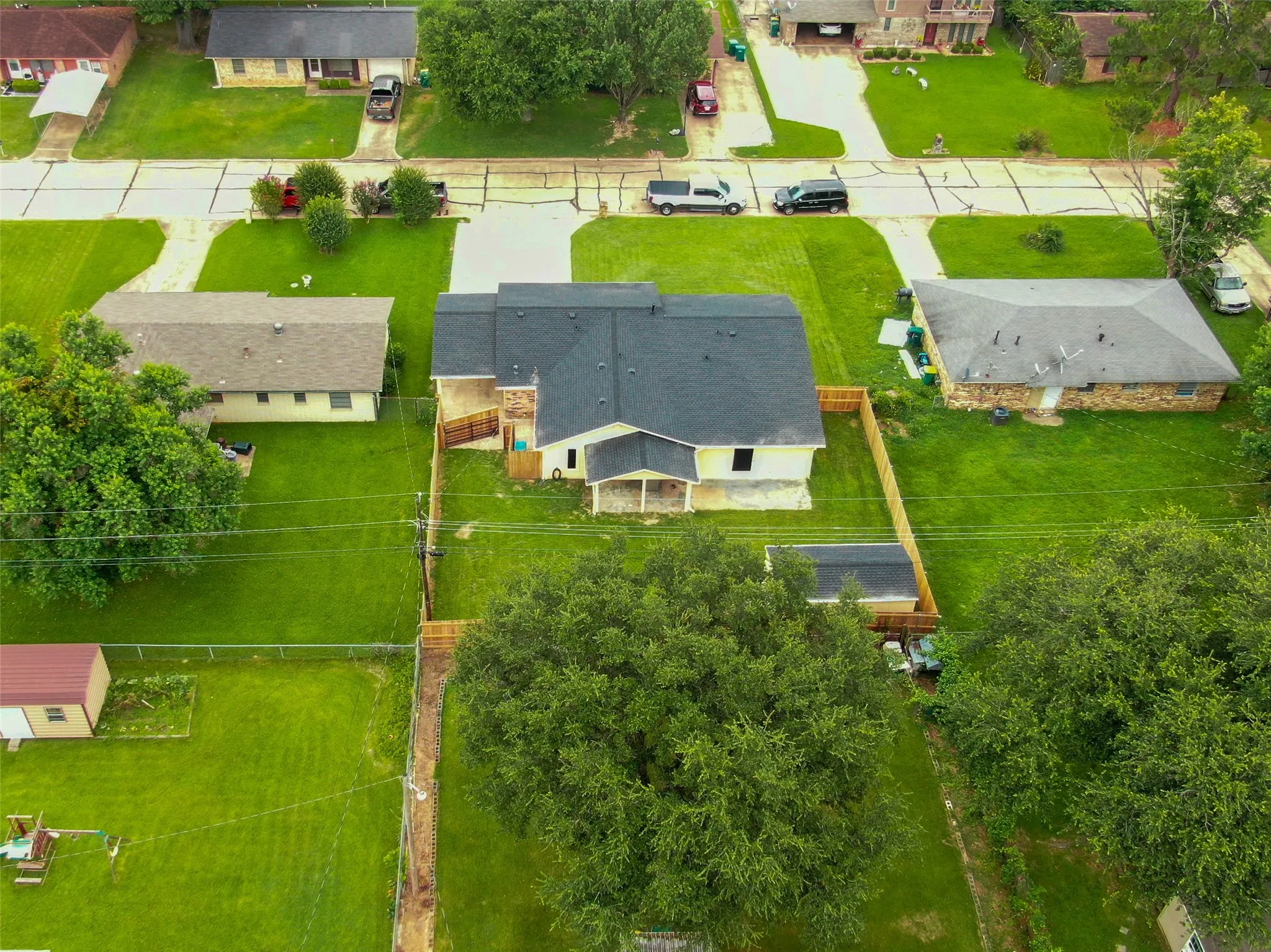 Single-story residence with a dark-tone roof, a fenced backyard, and established landscaping