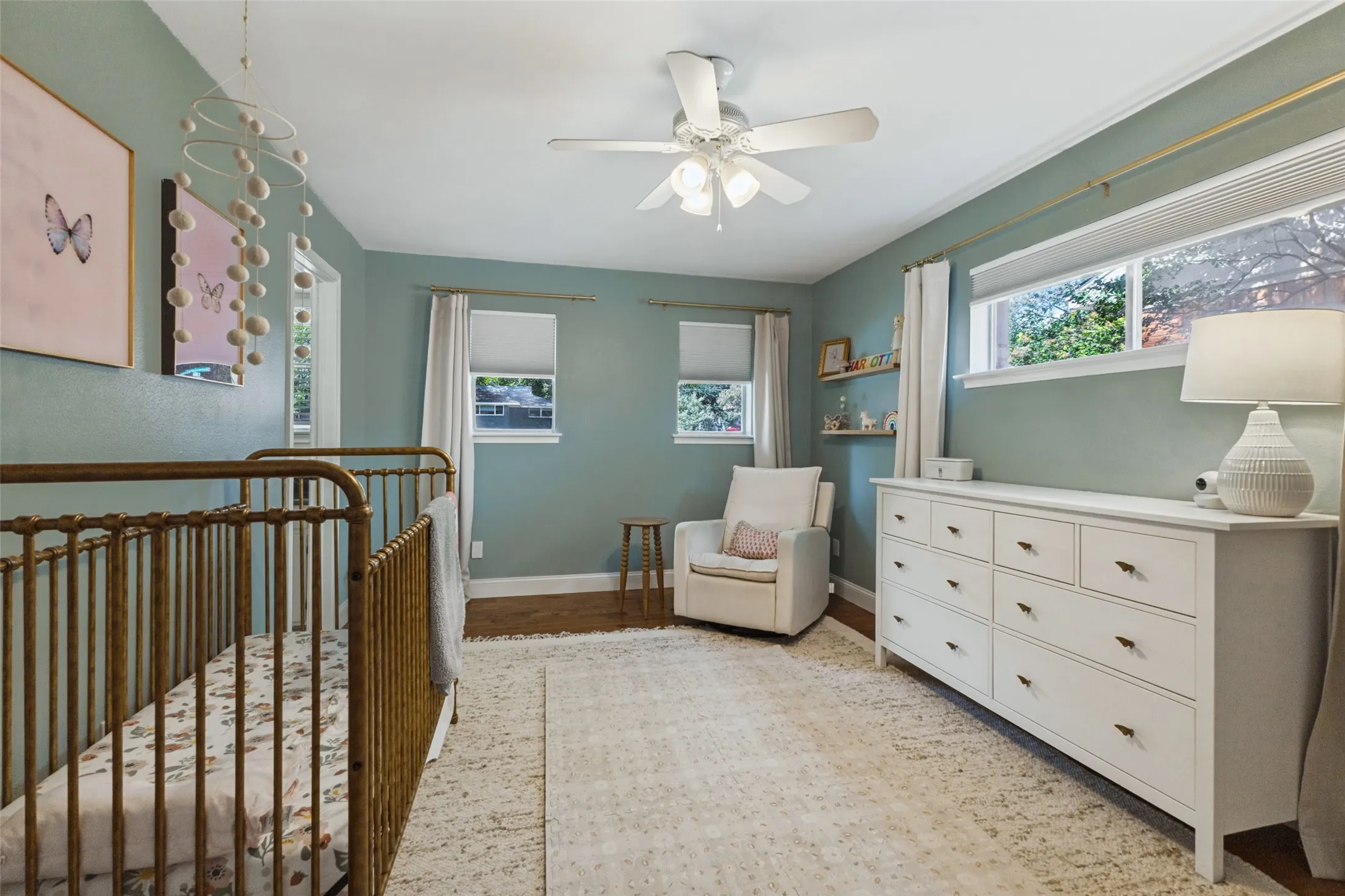 Wood-finish flooring, crown molding, and a ceiling fan with integrated lighting