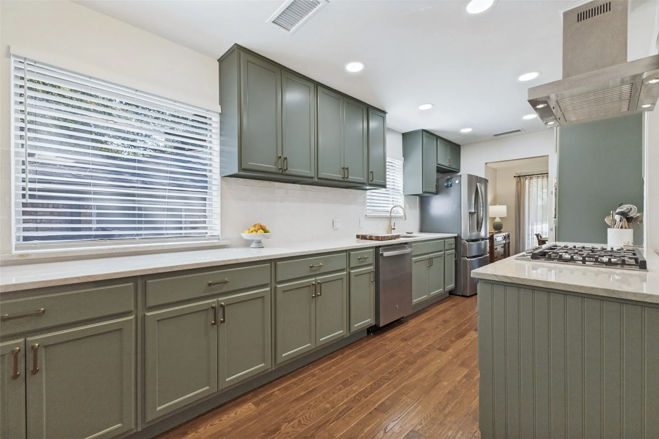 Kitchen featuring sage cabinetry, wood-finish flooring, recessed lighting, white countertops, and stainless steel appliances