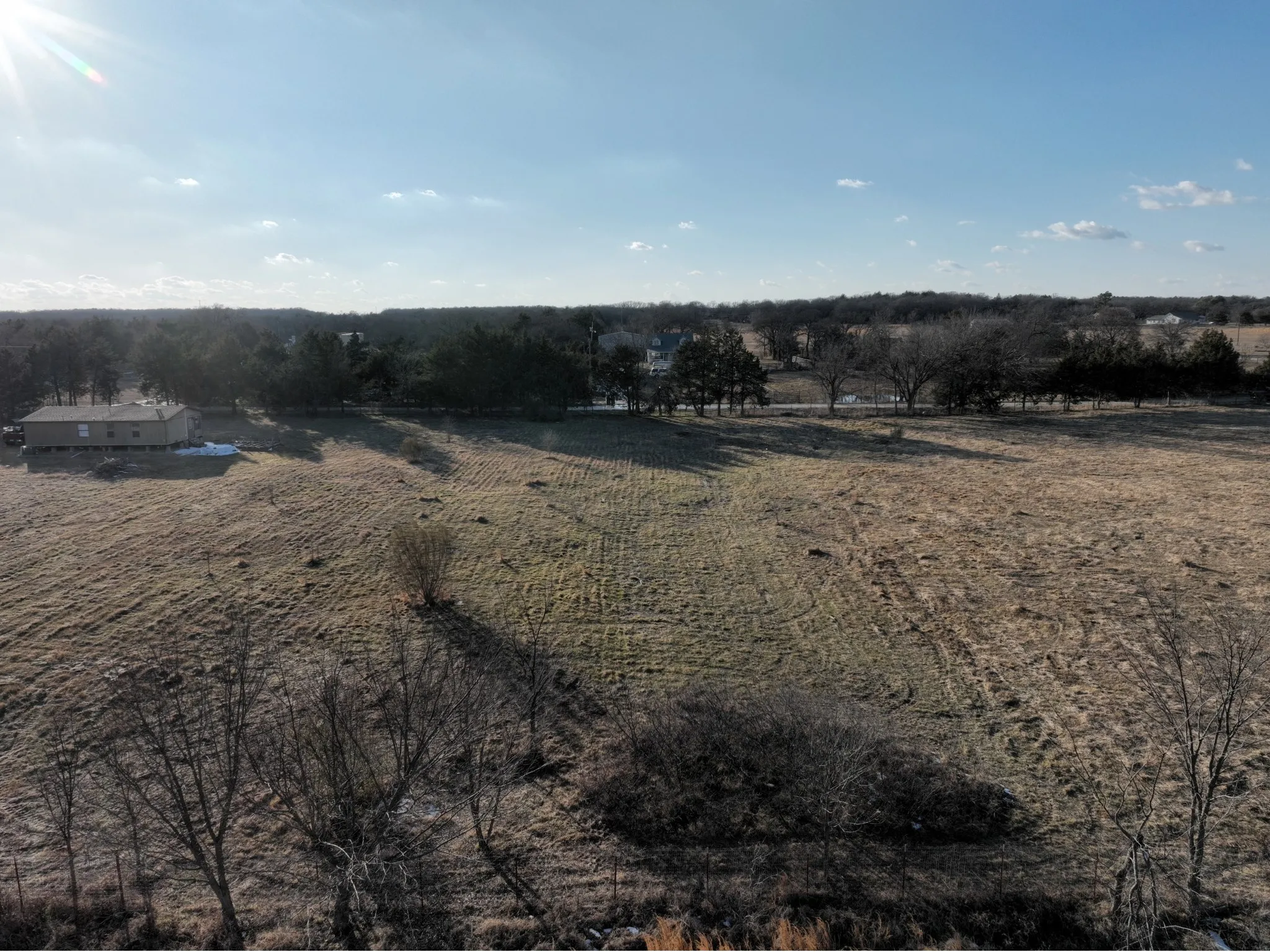 Expansive open land with a distant treeline and clear sky backdrop