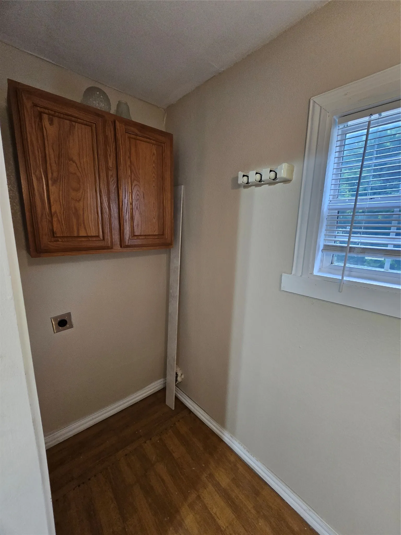 Laundry area featuring cabinet space, dark wood-style floors, and hookup for an electric dryer