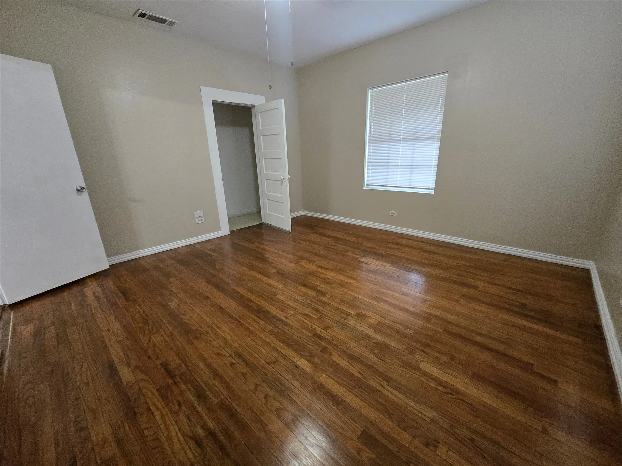 Unfurnished bedroom with dark wood-style floors and baseboards