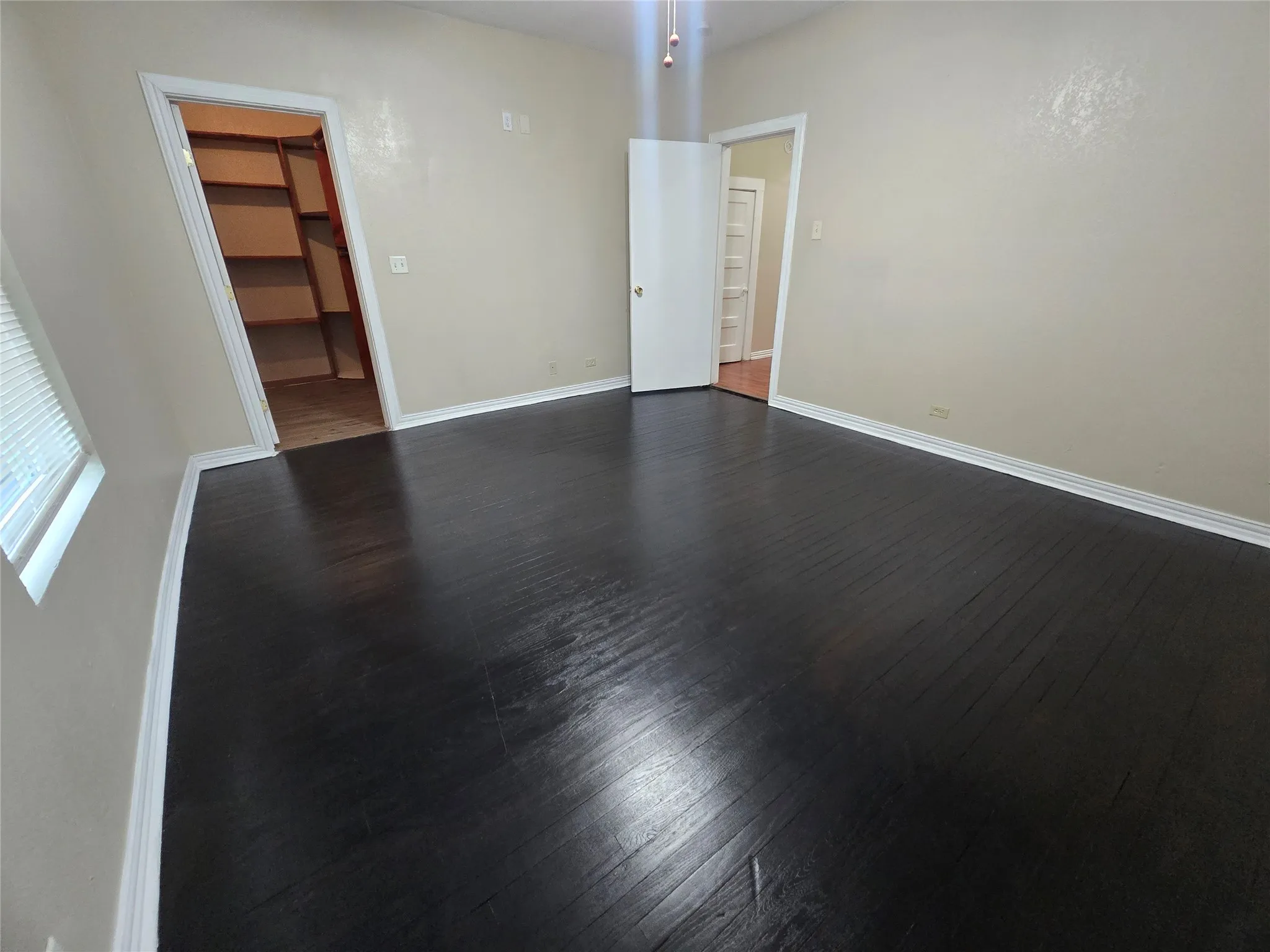 Unfurnished room with dark wood-style floors and baseboards