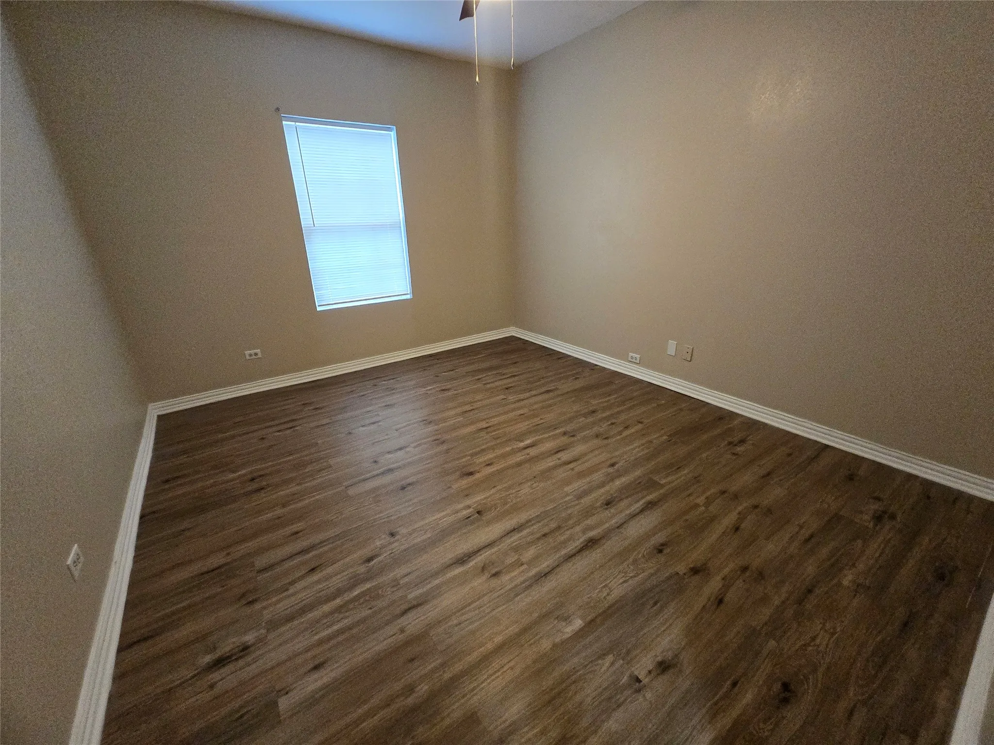 Empty room with dark wood-type flooring and ceiling fan