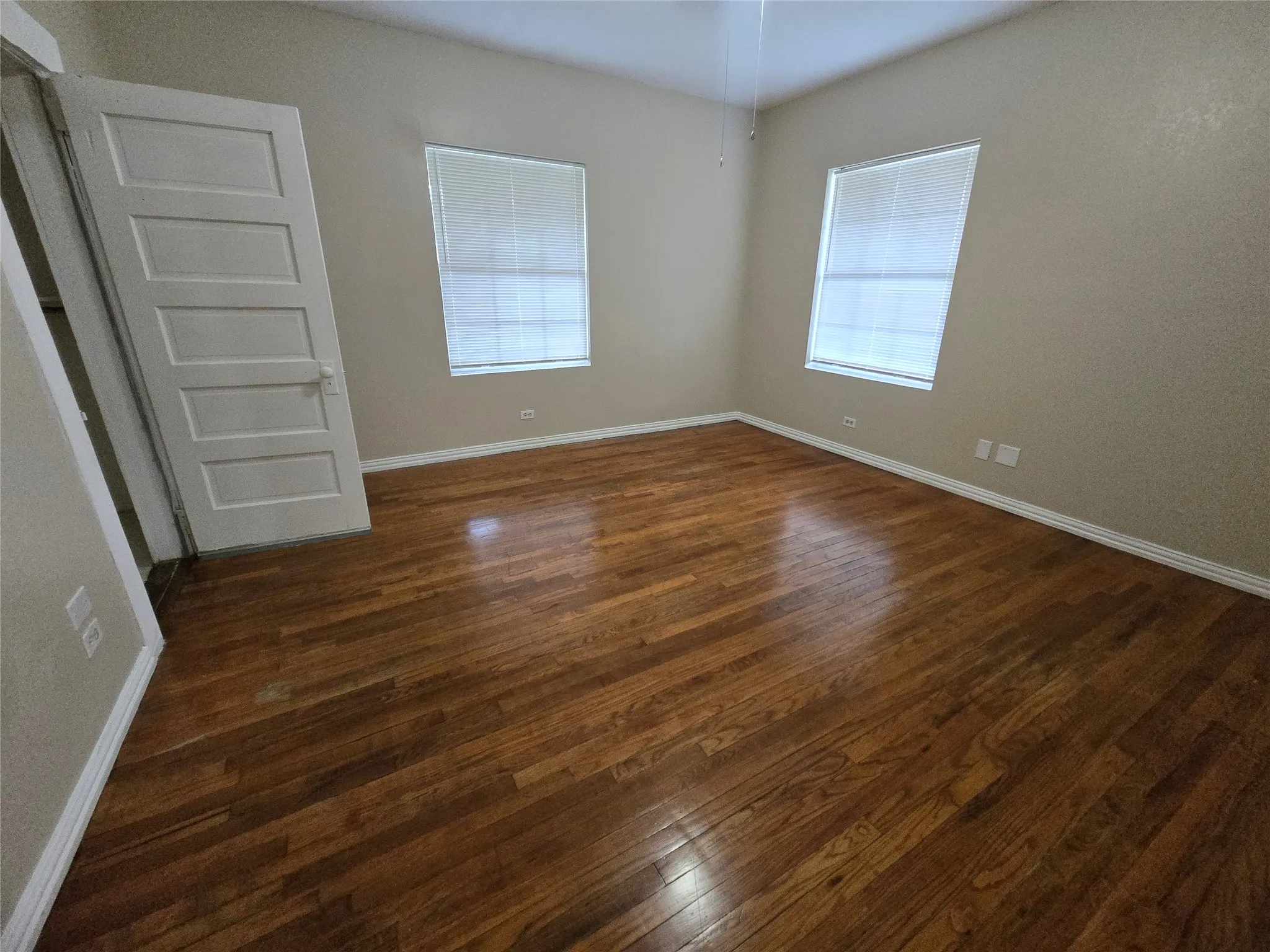 Unfurnished room with dark wood finished floors and baseboards