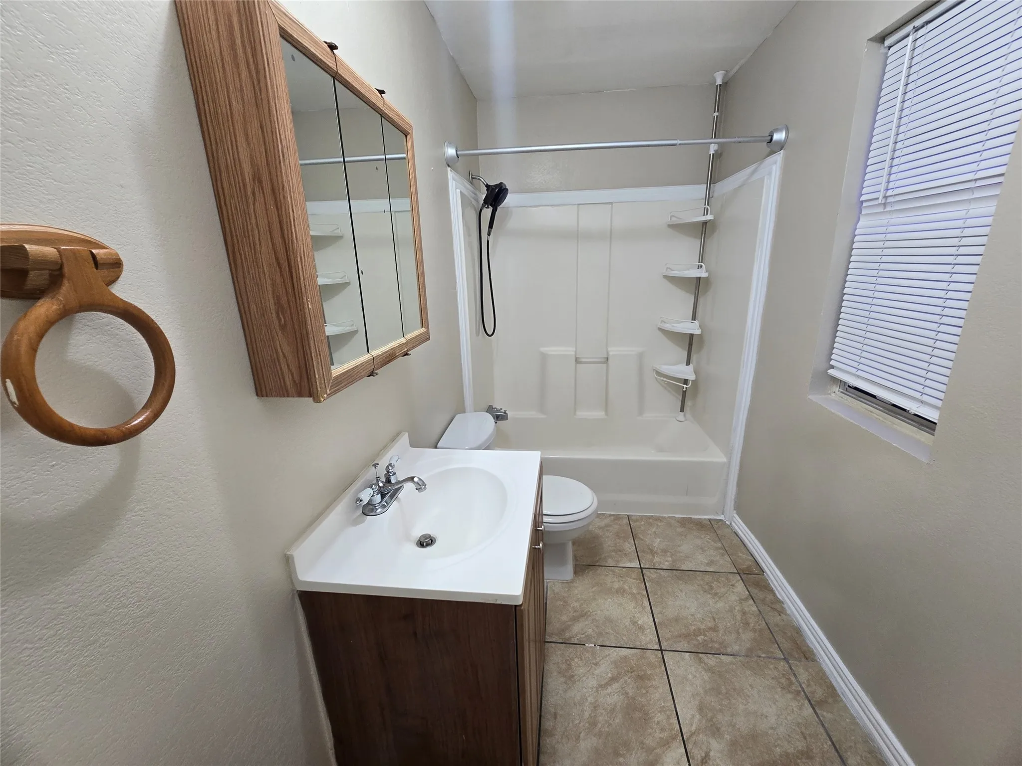 Bathroom with vanity, shower / washtub combination, and tile patterned flooring