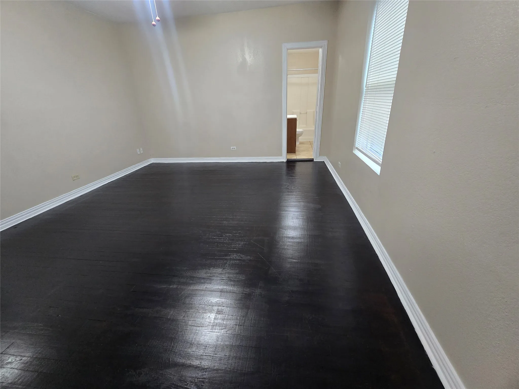 Unfurnished room featuring dark wood-type flooring and baseboards