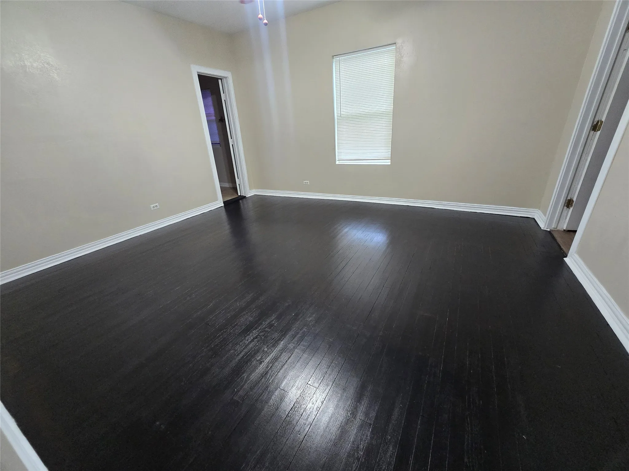 Unfurnished room with dark wood finished floors and baseboards