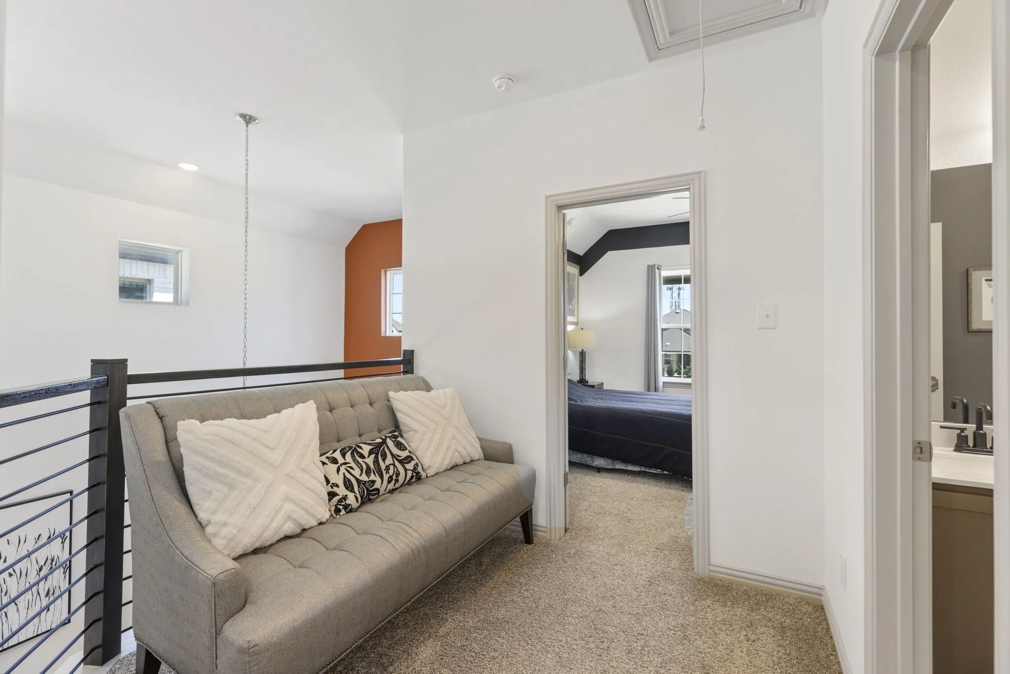 Carpeted upper level featuring a metal railing, vaulted ceiling, and recessed lighting