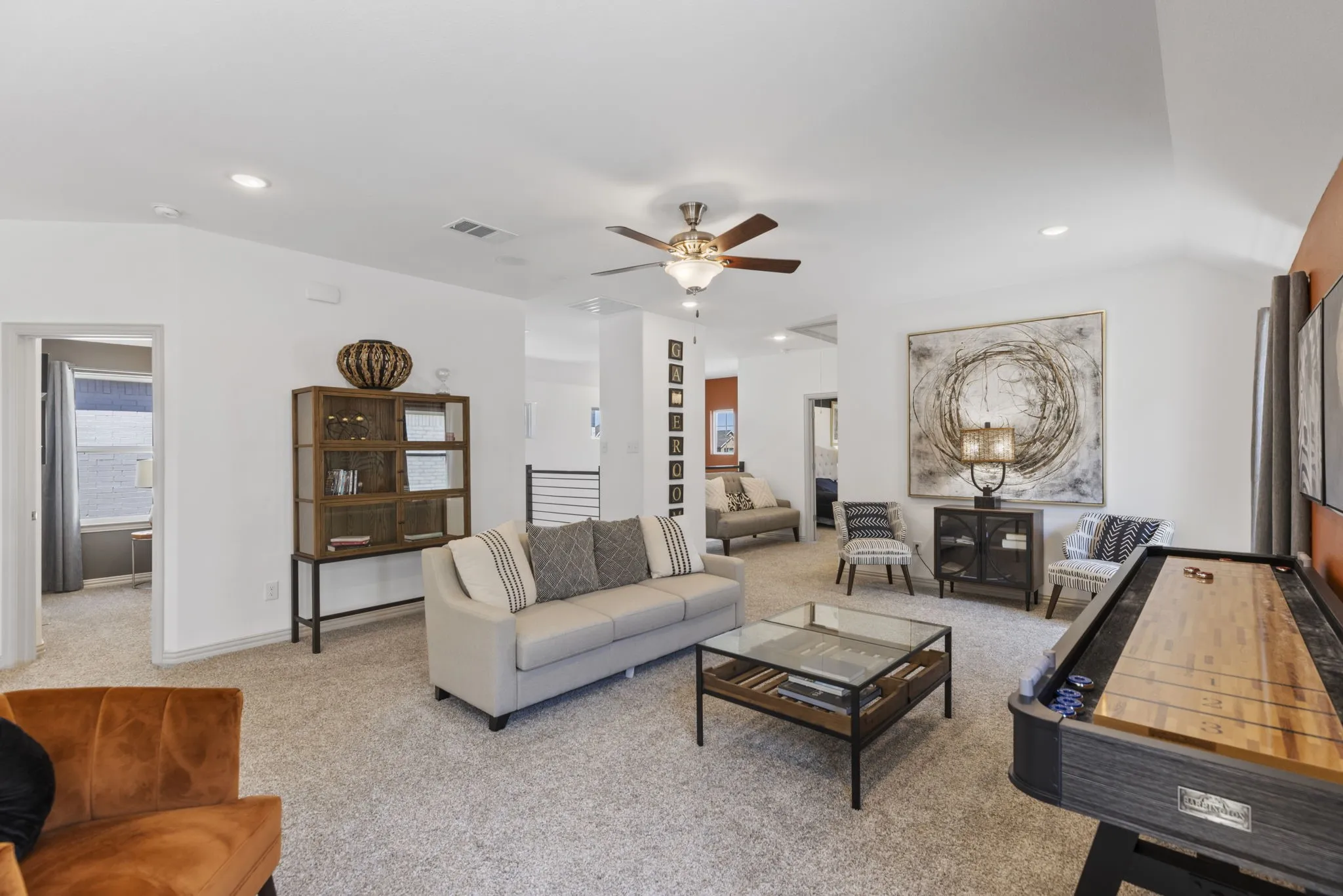 Spacious room featuring vaulted ceilings, recessed lighting, a ceiling fan, and light-toned carpet flooring