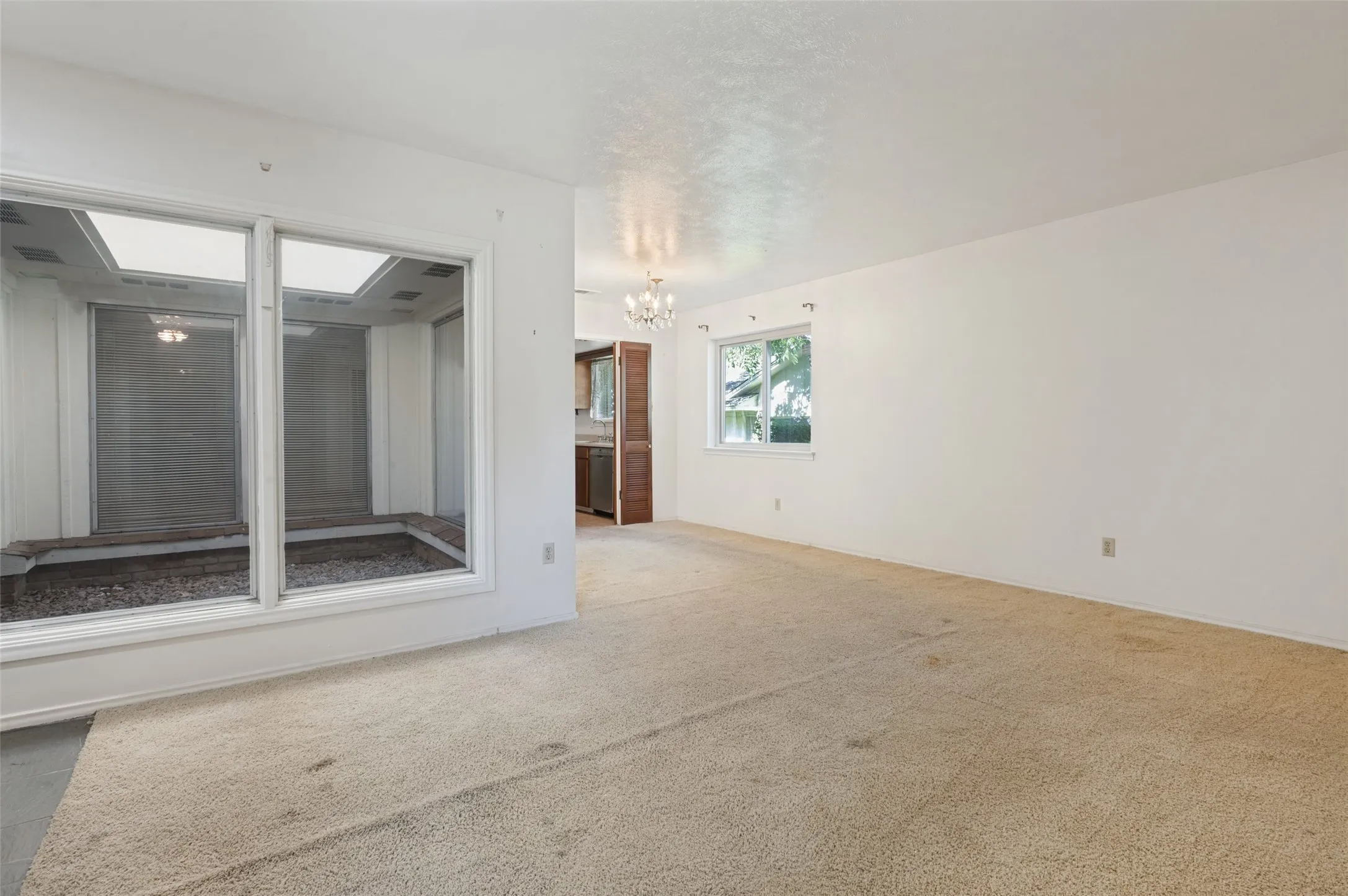 Spacious interior featuring neutral carpeting and white wall finishes