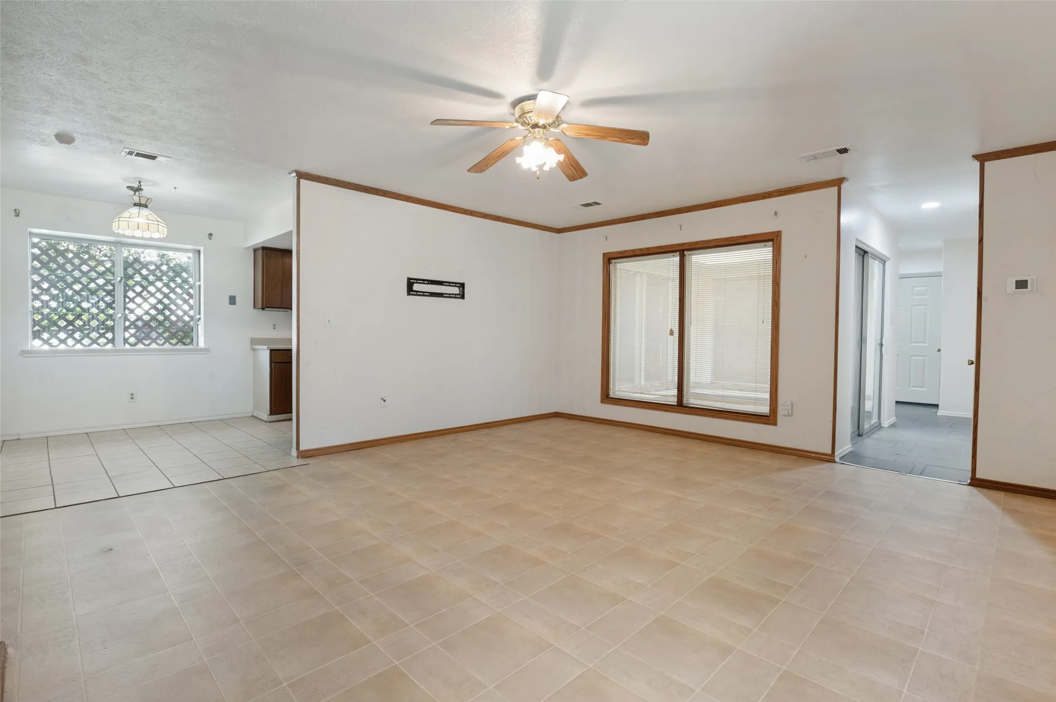 Spacious room with neutral tile flooring
