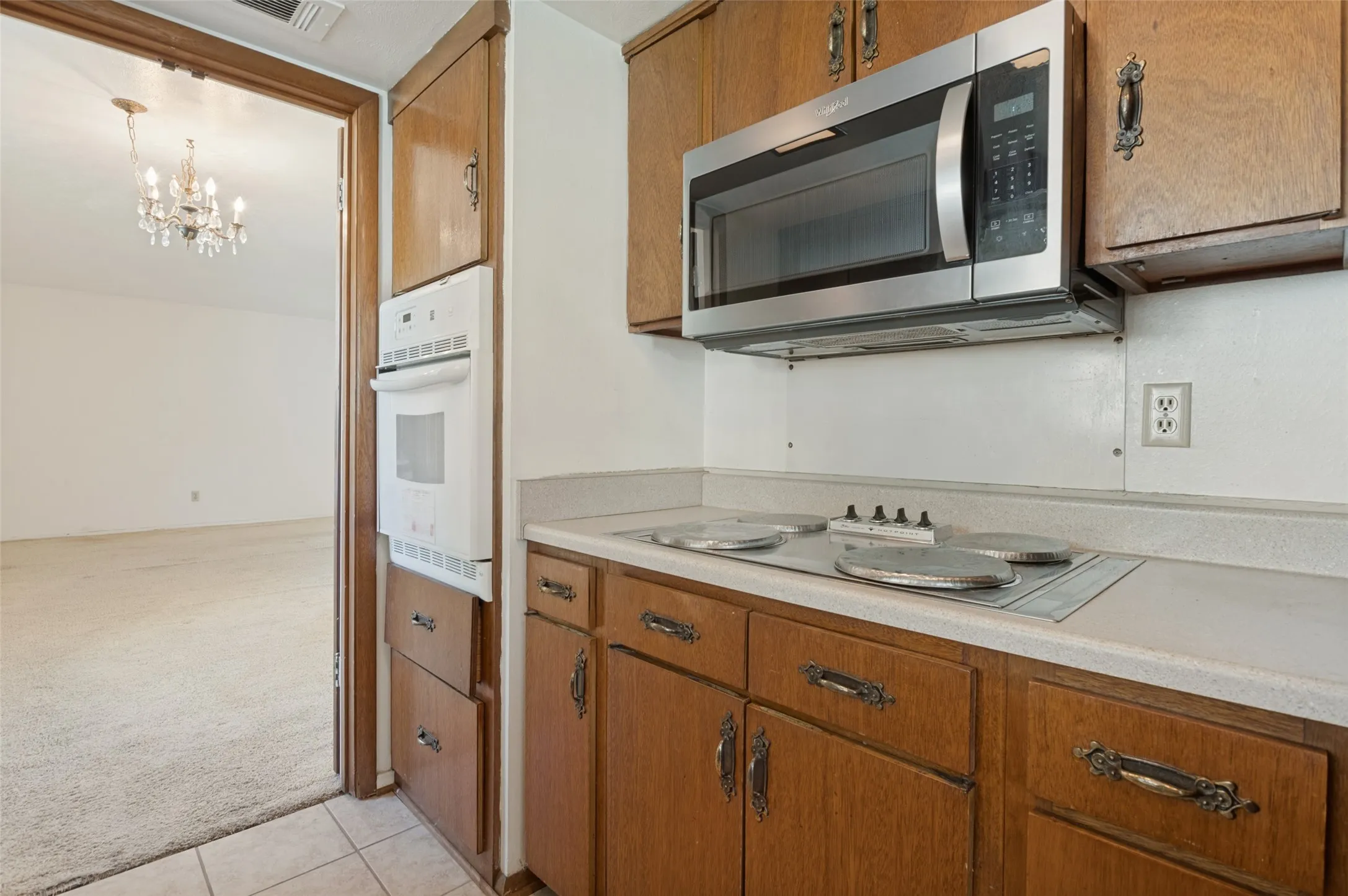 Kitchen featuring wood cabinetry, built-in wall oven, and a stainless steel microwave