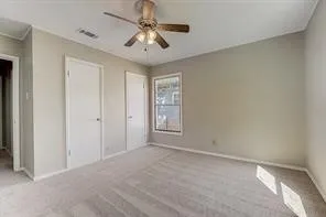 Recessed ceiling fan with integrated lighting, window with white trim, two white doors with dark hardware, and light-colored carpeting
