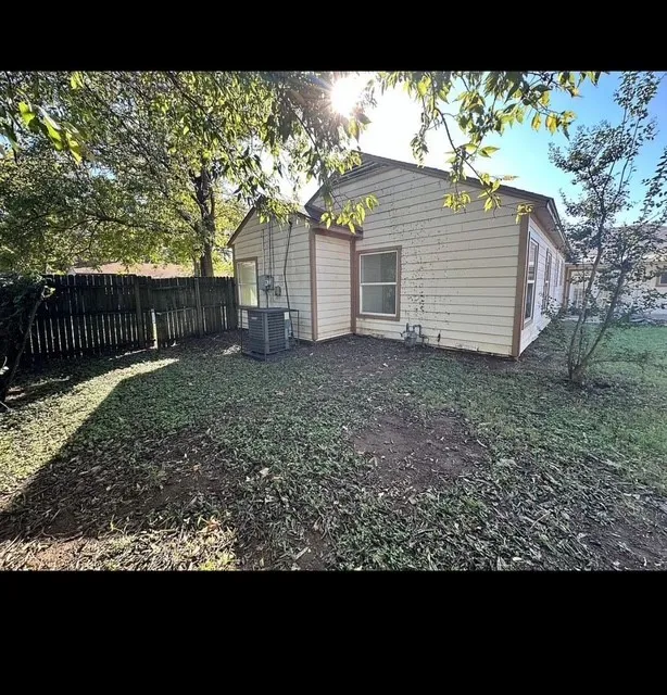Rear exterior with horizontal siding and a fenced perimeter