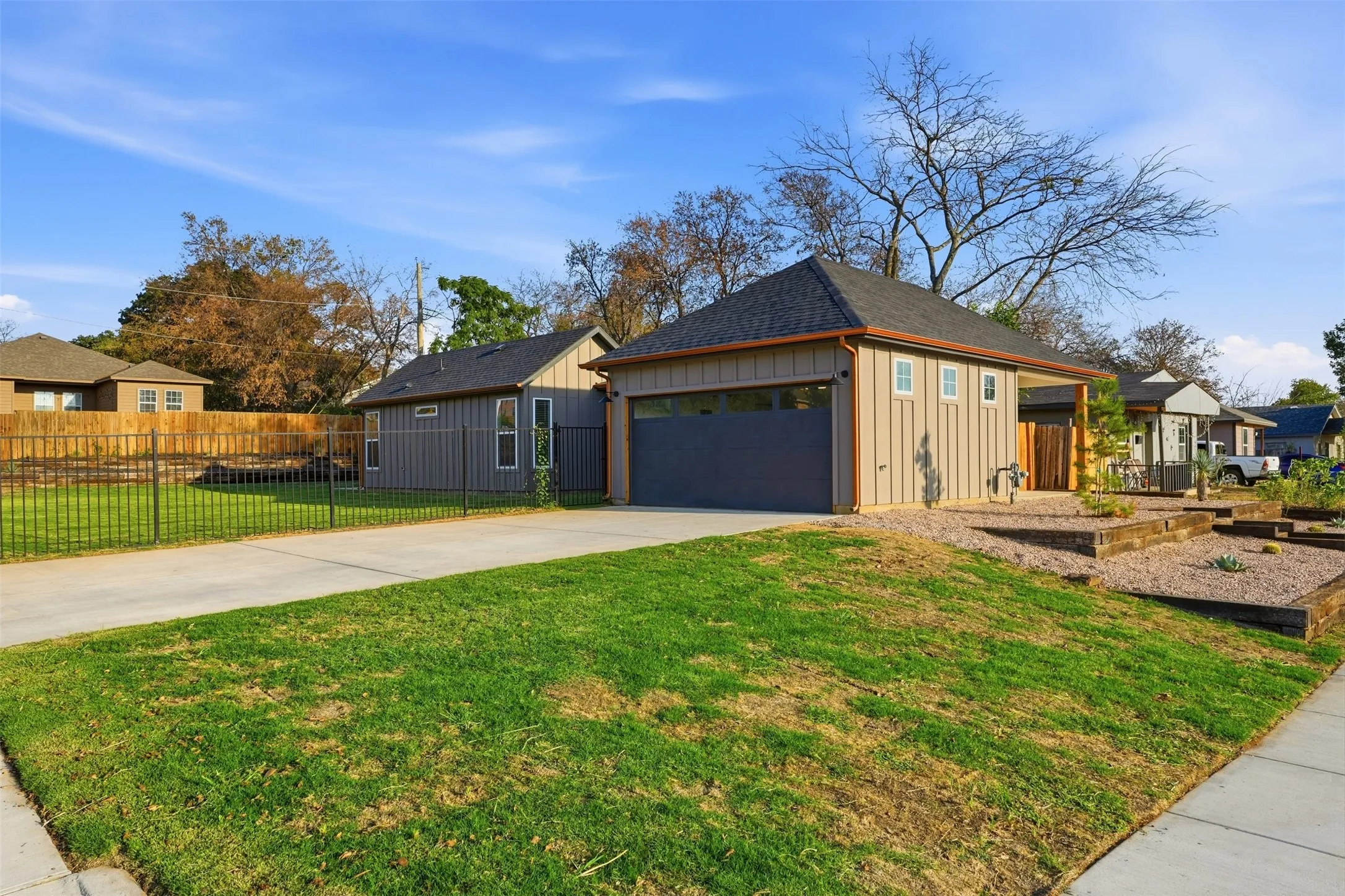 Detached garage building with board and batten siding and a dark roof