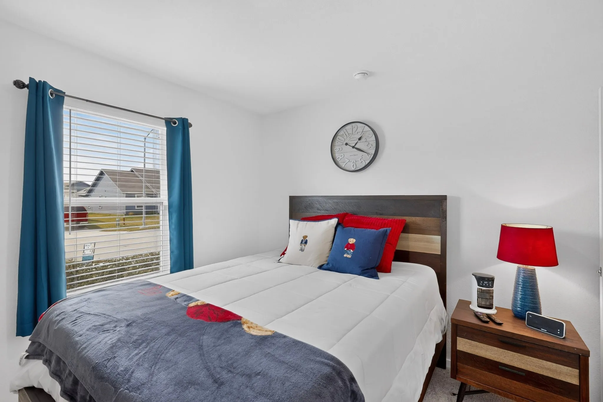 Recessed ceiling light, white painted walls, window with blinds, wood-finish flooring, and a multi-toned wood headboard