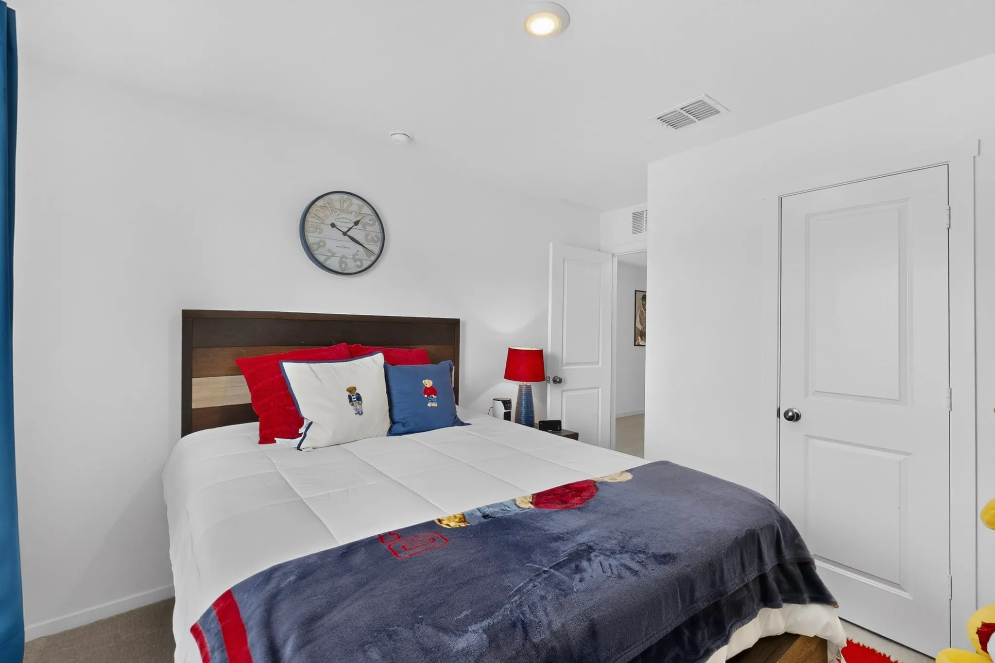 Recessed ceiling lighting, white interior doors, and a wood-panel headboard