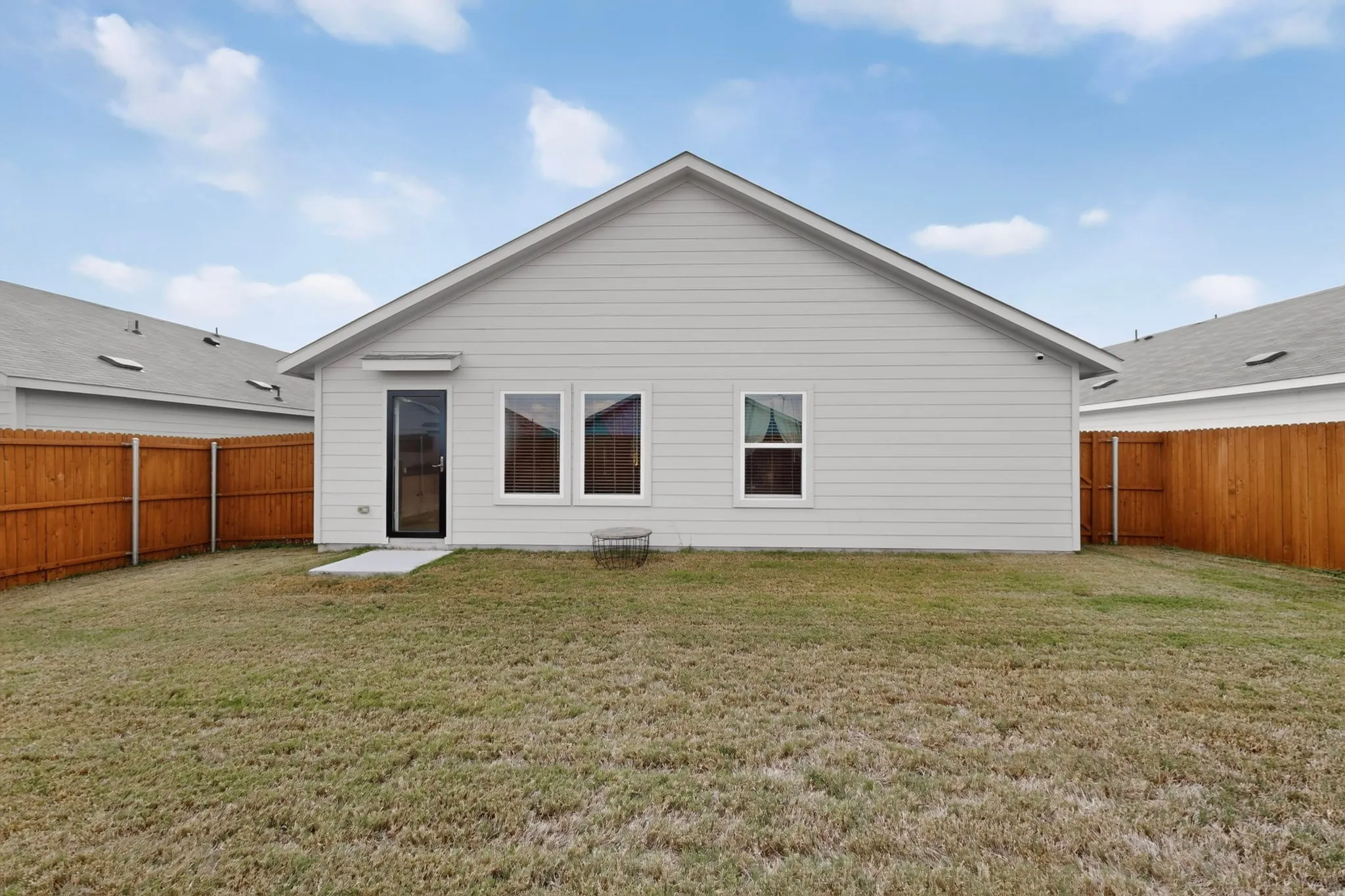 Expansive grass yard with a wood fence perimeter