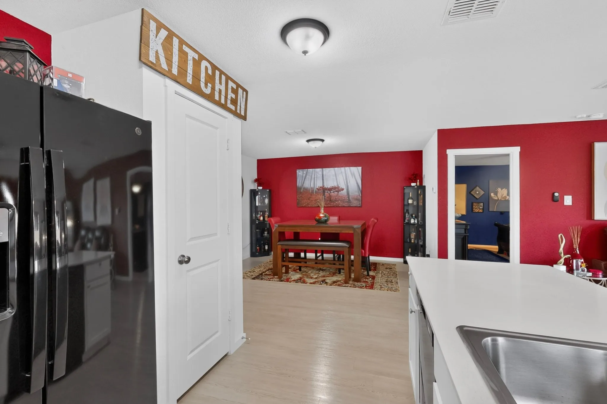 Wood-finish flooring throughout, white interior doors, and a built-in stainless steel sink