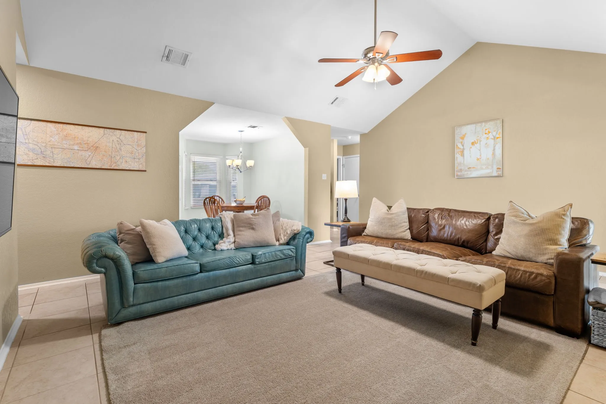 Vaulted ceiling with a ceiling fan, tile flooring, and an arched doorway